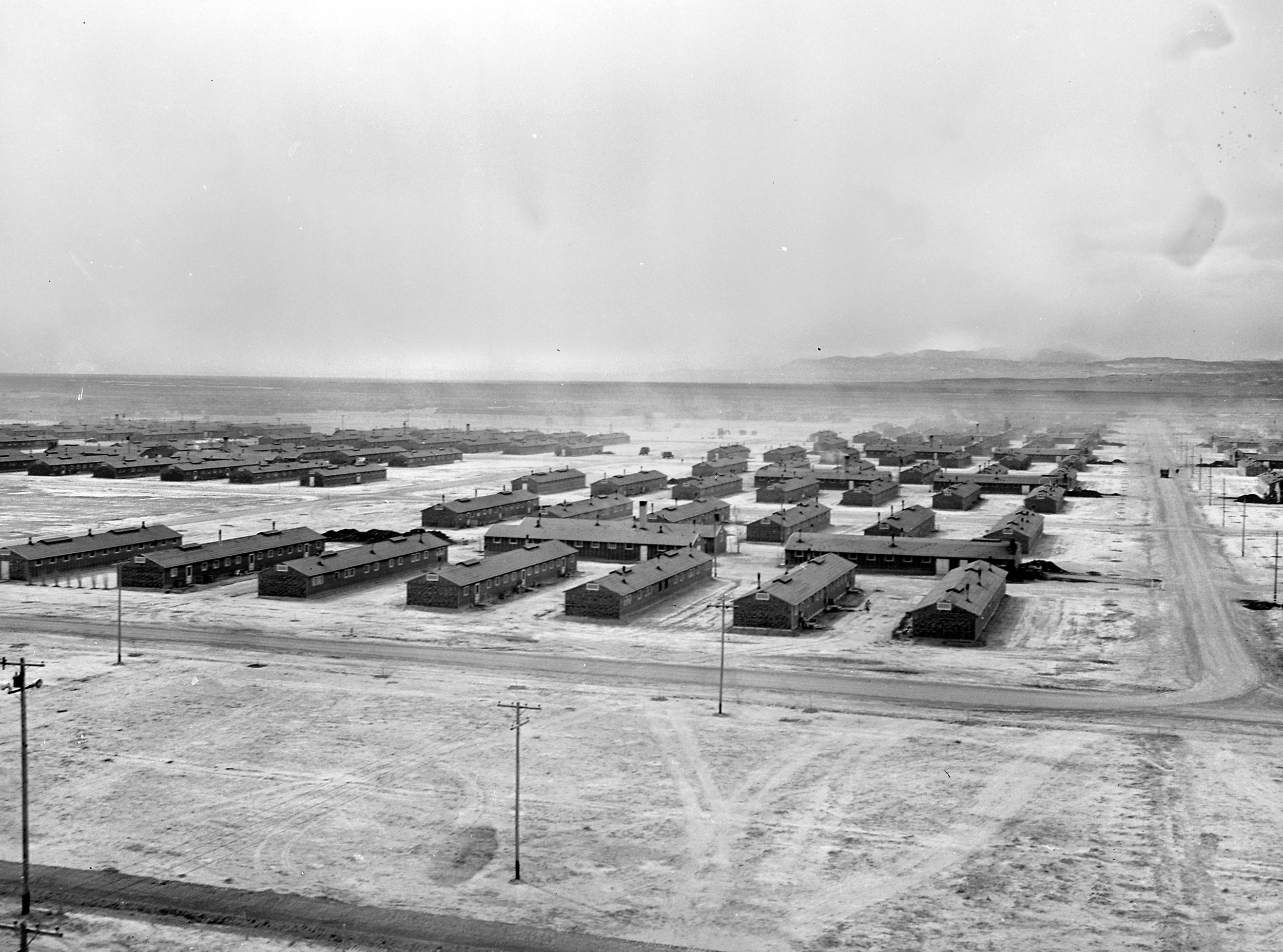 This bleak 1942 aerial view depicts the relocation center at Topaz, Utah. The center became the temporary home of 9,000 Japanese-Americans who were forcibly removed from areas on the U.S. West Coast. The camp was closed in October 1945.