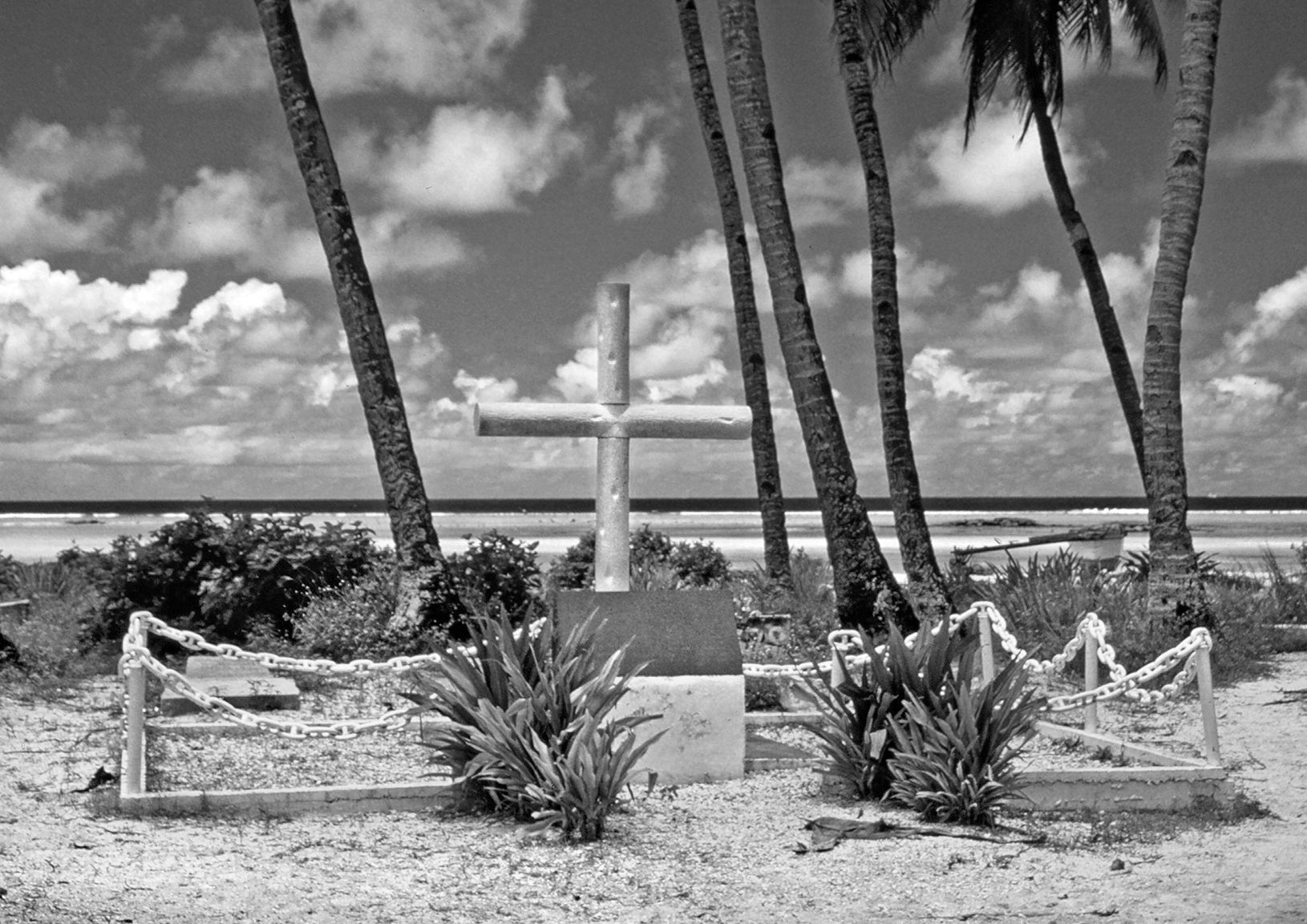 In 1943, U.S. Marines erected a makeshift cross of coconut logs as a memorial for the 22 victims of the Japanese executions of Allied prisoners on Betio. A permanent concrete memorial, shown here, was later constructed.