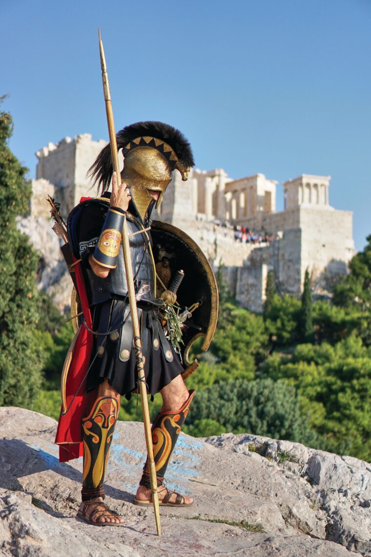 With the Acropolis of Athens as a backdrop, a modern reenactor portrays a Greek hoplite.