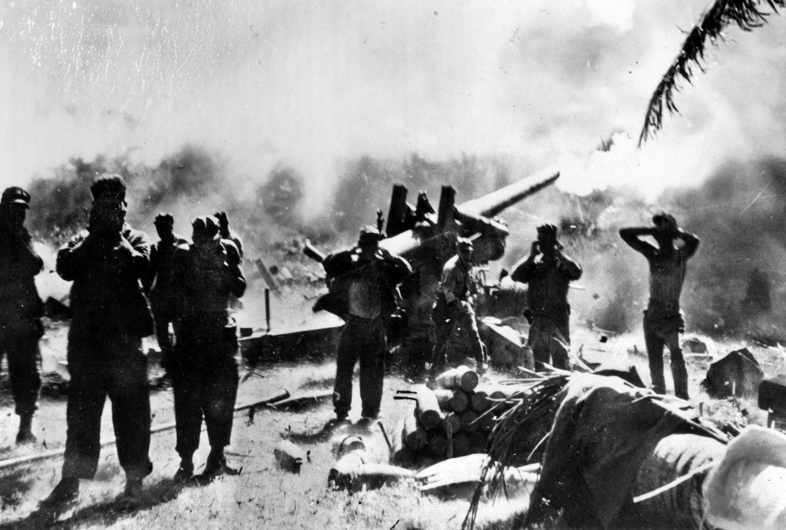 U.S. Army soldiers cover their ears and turn their backs as the155 mm “Long Tom” field artillery gun is fired at Japanese troops moving to the Carigara Front on Leyte Island, Philippines.