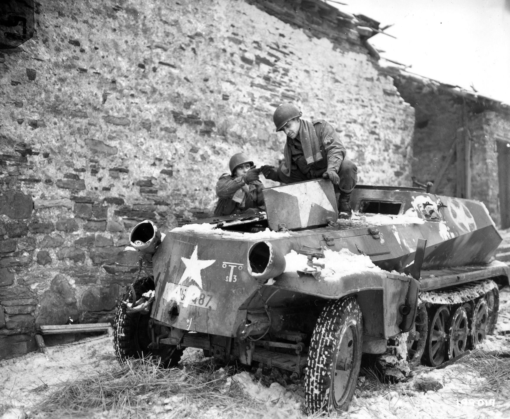 Soldiers of the 334th Infantry Regiment try to repair a German armored vehicle, Sd.Kfz. 250 of 146 Artillery Regiment, 116th Armored Division of the Wehrmacht, captured by the Allies in Belgium, January 1945. German losses in tanks and troops as a result of the Battle of the Bulge were irreplaceable, and Hitler’s desperate offensive actually contributed to shortening the war in Europe. 