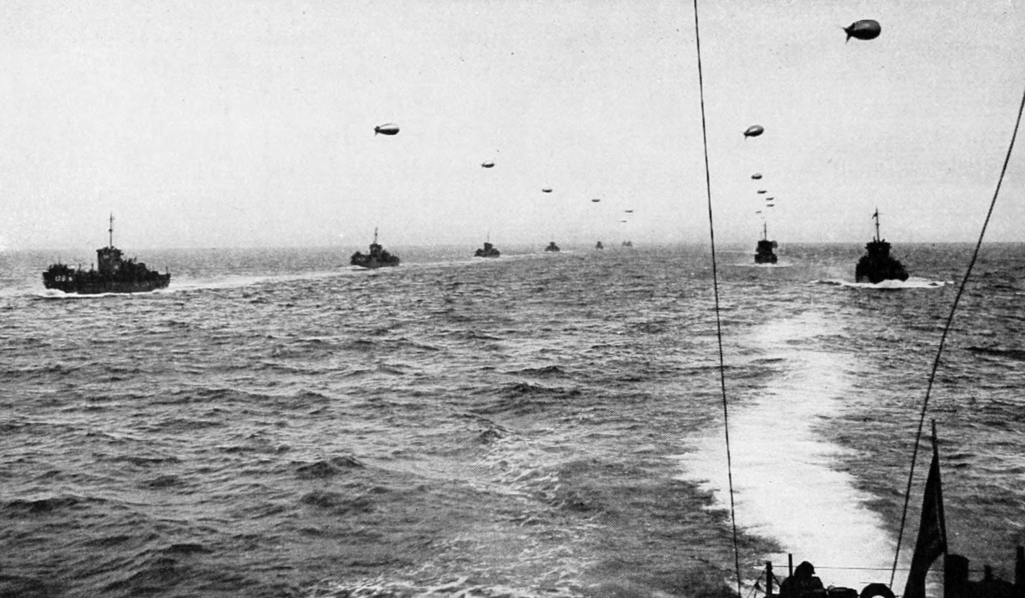 Allied landing craft approach the coast of French Normandy on D-Day with barrage balloons aloft to protect from attacks by enemy aircraft. The balloons were under the control of the 320th Barrage Balloon Battalion before and after landing on Utah and Omaha Beaches on June 6, 1944.