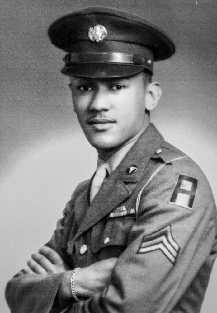 Corporal Waverly Bernard Woodson, Jr., a medic with the 320th Barrage Balloon Battalion, was wounded on D-Day when his landing craft struck a mine and was hit by German artillery. Disregarding his own wounds, Woodson established an aid station and treated other wounded men for 30 hours. Recommended for the Medal of Honor, he instead received the Bronze Star and Purple Heart for his actions on June 6, 1944. 