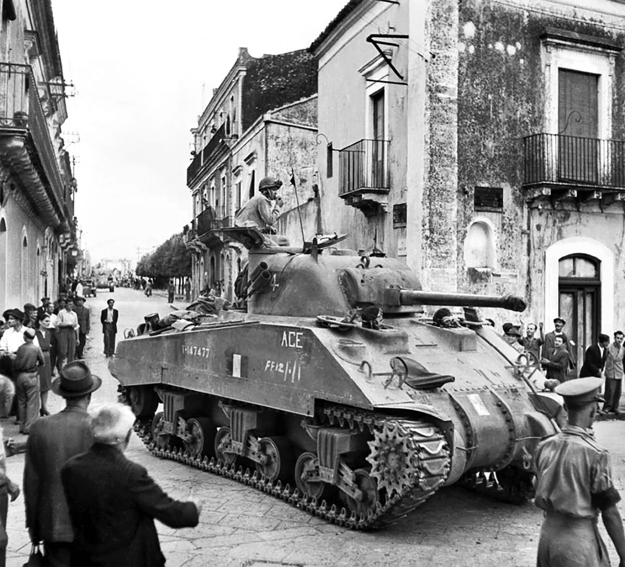 An M4 Sherman medium tank of the Ontario Regiment rumbles through the streets of Trecastagni during Operation Husky, the Allied invasion of Sicily, in August 1943. Canadian forces were later heavily engaged in the campaign on the Italian mainland.