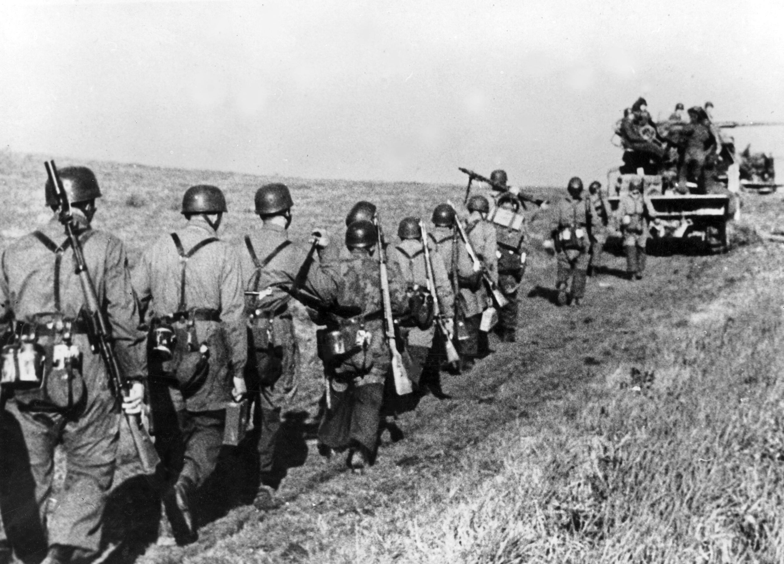 German Fallschirmjager, elite paratroopers, are shown moving along a dusty road in Italy. After a stubborn defense of Monte Cassino, the Fallschirmjager were finally compelled to retreat. The soldier at the rear is carrying a Mauser Kar98k rifle used for firing grenades.