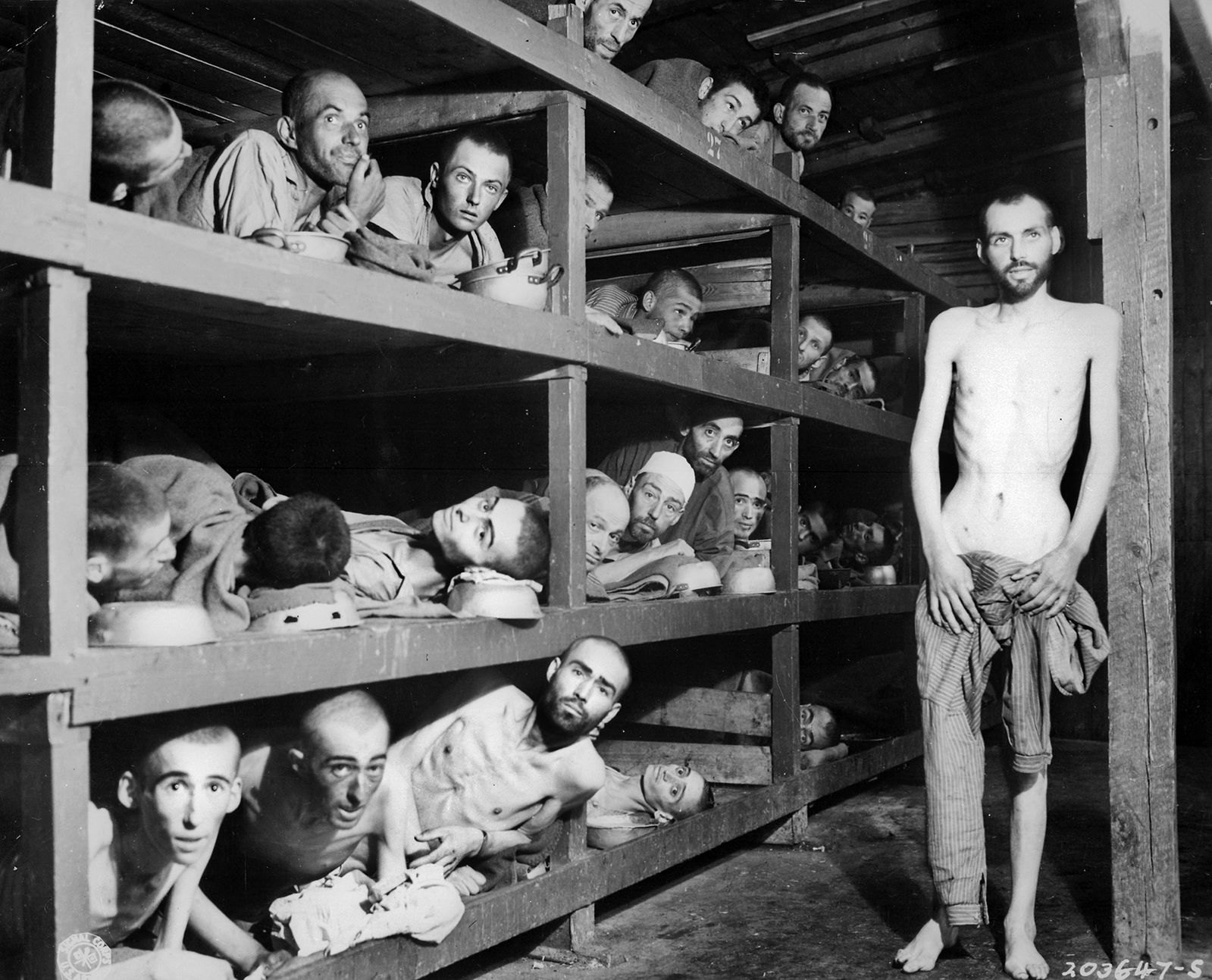 Many with hollow stares and others suffering from malnutrition and disease, prisoners are photographed in the concentration camp at Buchenwald after their liberation by troops of the U.S. Army’s 80th Infantry Division.