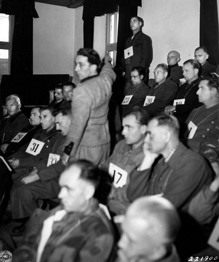 Rudolf Wolf, who testified that more than 600 prisoners at Dachau had been killed in a “death march,” points to Franz Trenkle, number four on the list of 40 accused Nazi torturers at Dachau being tried for their actions. This notorious Nazi concentration camp, which became the scene of the trials, is located near the Bavarian city of Munich, Germany, and the photo was taken on November 20, 1945.