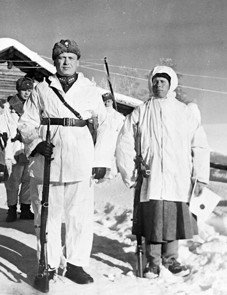 Colonel Antero Svensson stands at left with Häyhä after presenting the prolific sniper with a new rifle purchased by a Swedish businessman. Häyhä is holding a certificate that was presented along with the new sniper rifle.