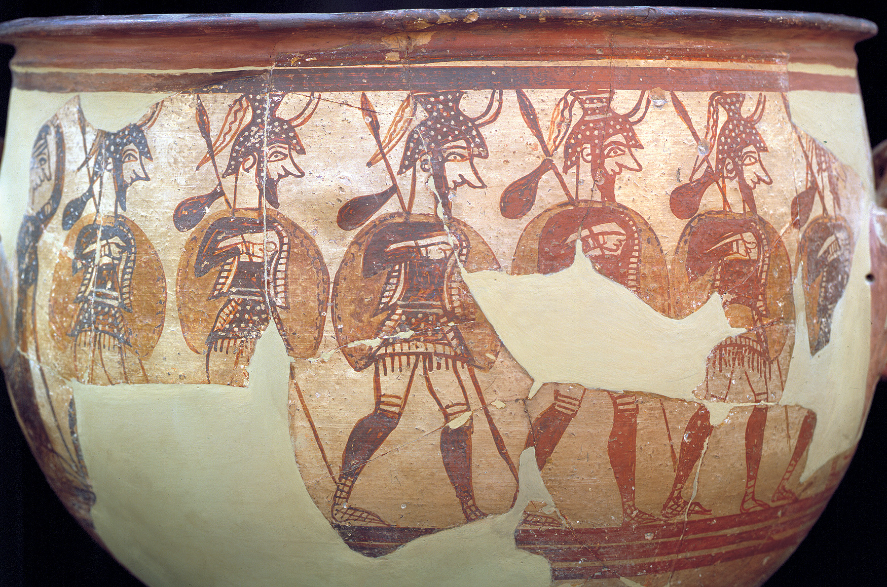 Soldiers march around a vase (c. 1200 bc) uncovered in Mycenae by Heinrich Schliemann. Plumes and horns rise from their helmets. Greaves of leather protect their legs, and their shields are small enough for easy handling.