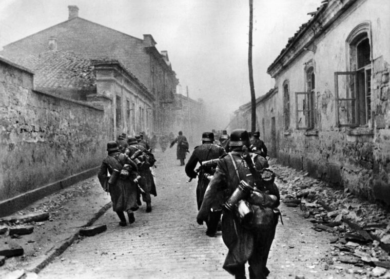 German soldiers rush through the streets of Brest at the start of the Axis invasion of Russia (Operation Barbarossa). In the early morning hours of June 22, 1941, the German army attacked the 19th century Fortress Brest, expecting little resistance to their Blitzkrieg tactics. But the Red Army held out until June 29, in spite of the devastating firepower wielded against them.