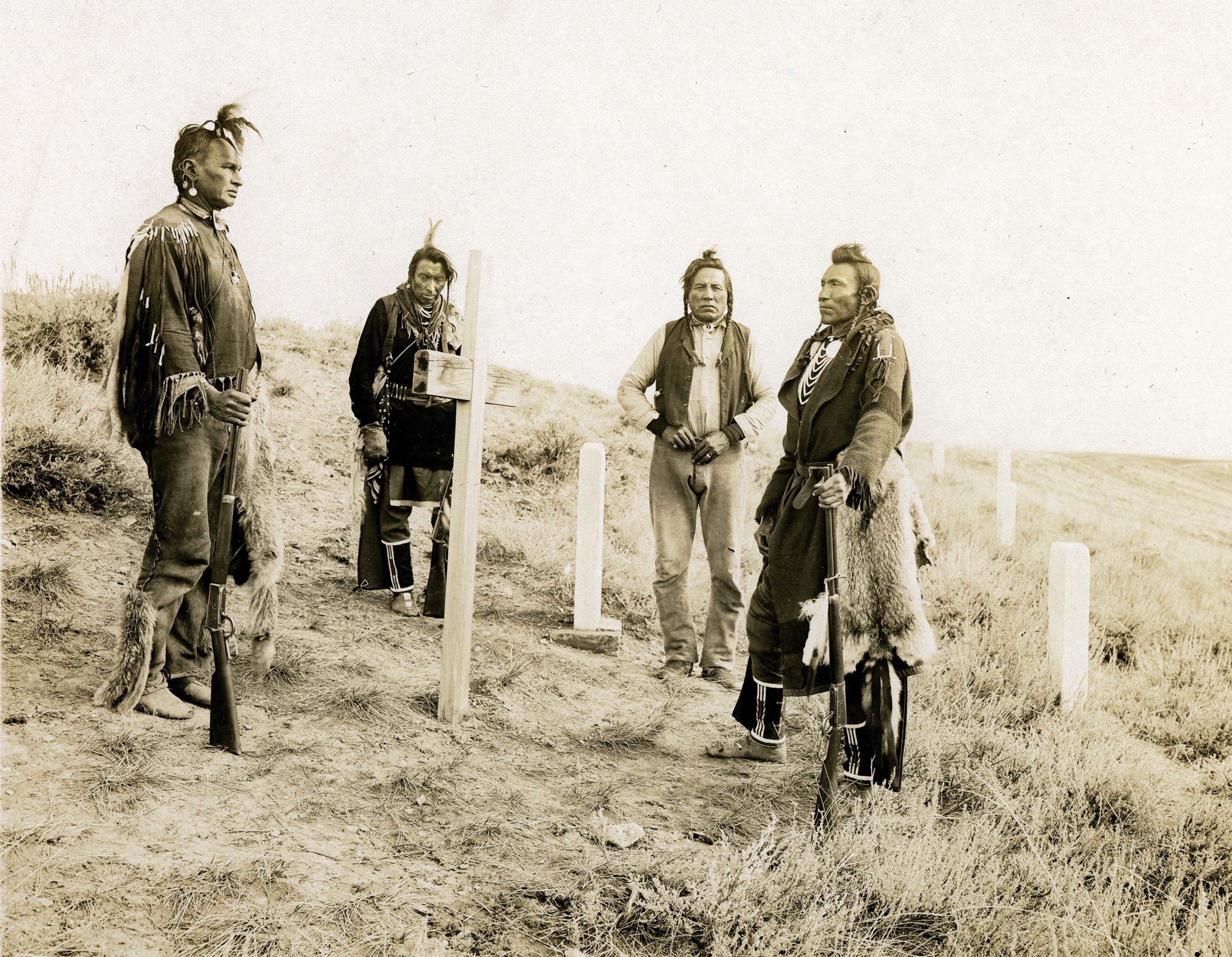 A 1913 photo of Lieutenant Colonel George A. Custer’s four Crow scouts—Hairy Moccasin, White Man Runs Him, Curly, and Goes Ahead—visiting the marker that shows where Custer fell at the Battle of Little Bighorn in 1876. 