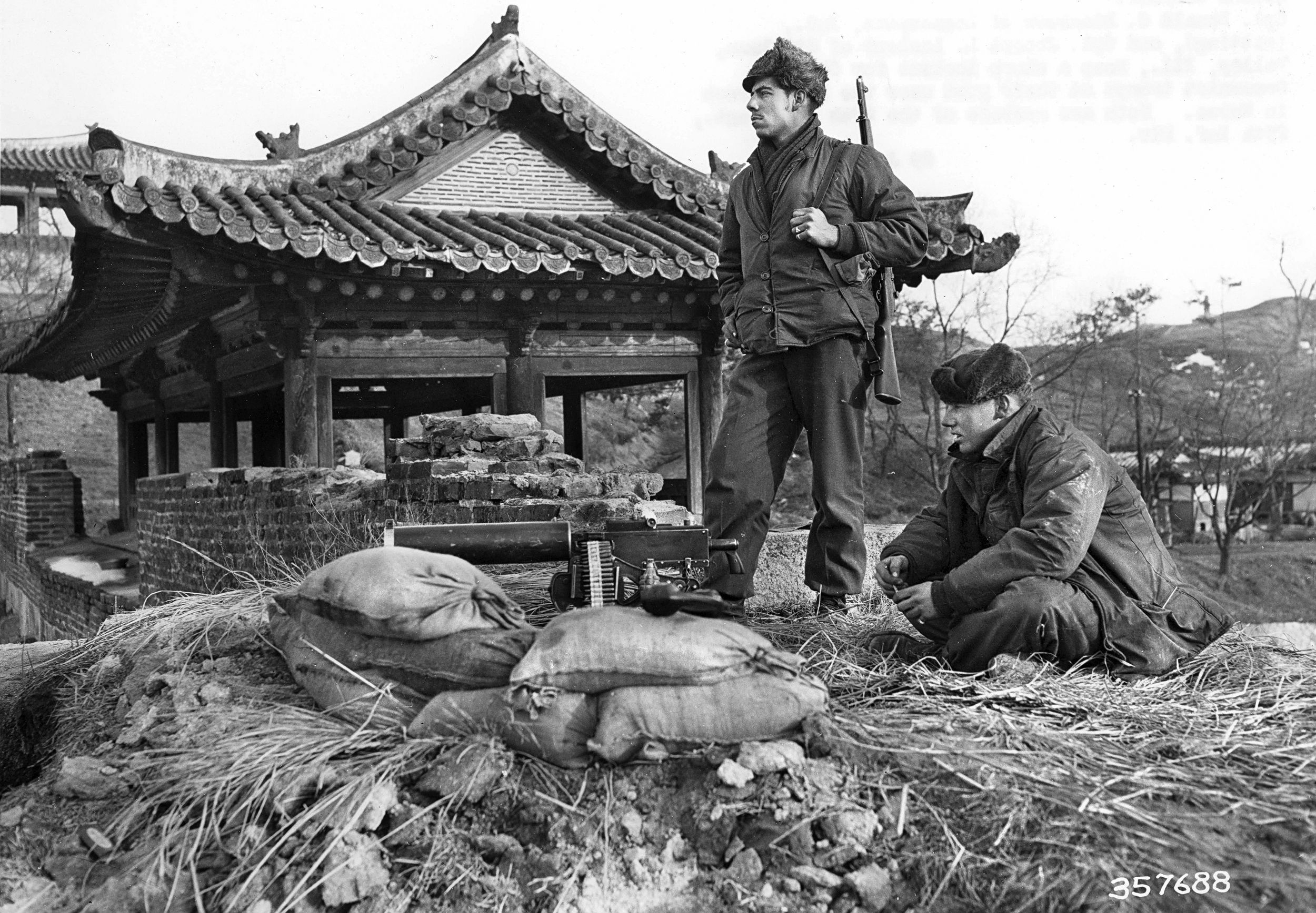 Corporals Donald Blackman and Joseph Lasleur of the 27th Infantry Regiment watch for Chinese Communists troops at their post near the front lines in Korea.