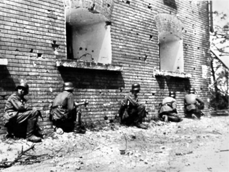 German soldiers take cover along building walls up to two meters thick.