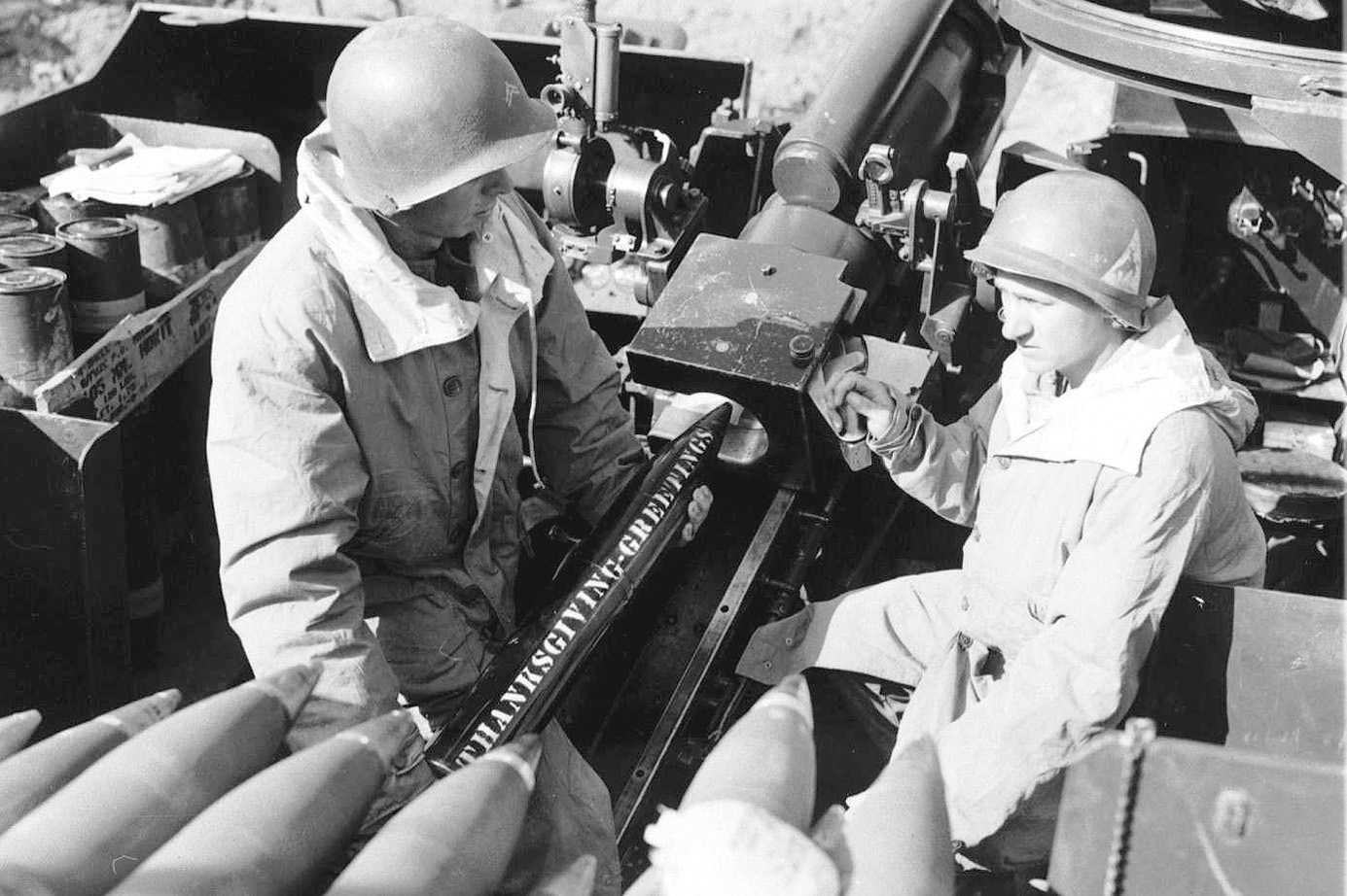 Soldiers of the 300th Field Artillery Battalion, one with unit insignia on his helmet.