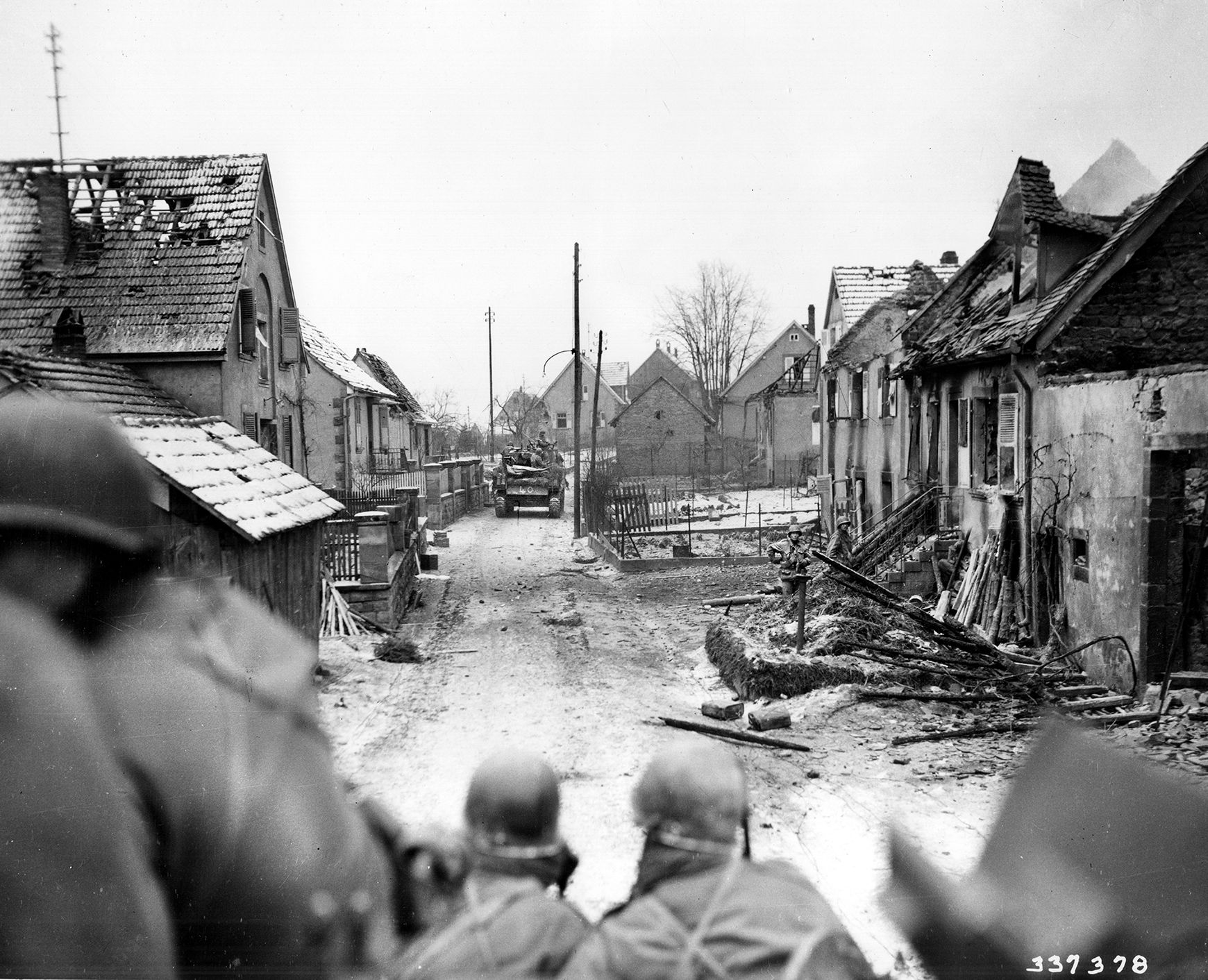 M4 Sherman medium tanks of the 781st Tank Battalion, fighting along with the 274th Infantry Regiment, move back into the town of Wingen, Germany, on January 7, 1945, after it has been retaken from the Germans. The medical detachment of 2nd Battalion has already set up an aid station nearby to deal with heavy casualties.