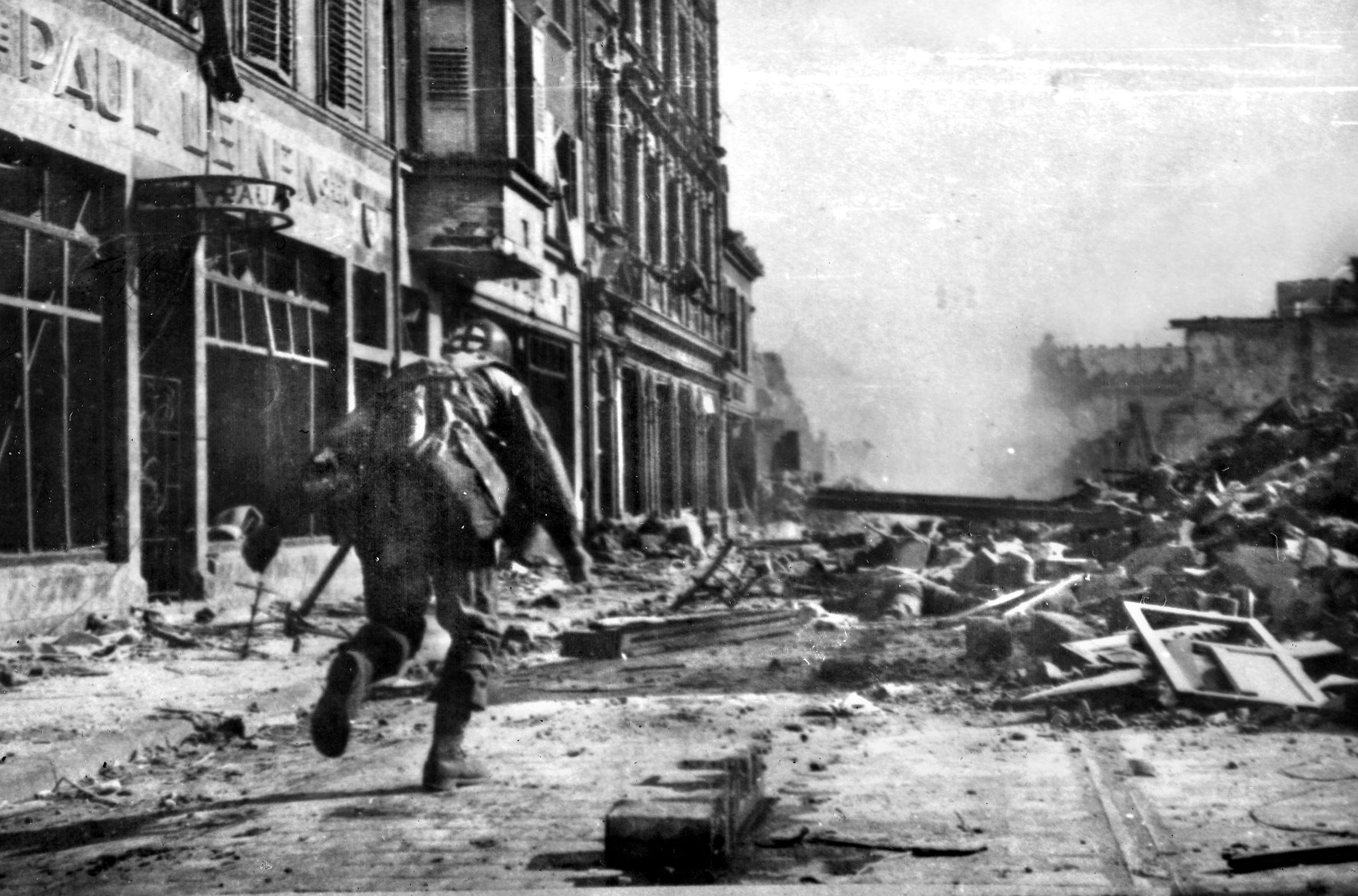 Under enemy fire, a medic dashes into the open and down a city street while moving forward to treat wounded soldiers. Such a scene became commonplace, and the medical detachment of the 274th Infantry Regiment displayed great courage under fire. 