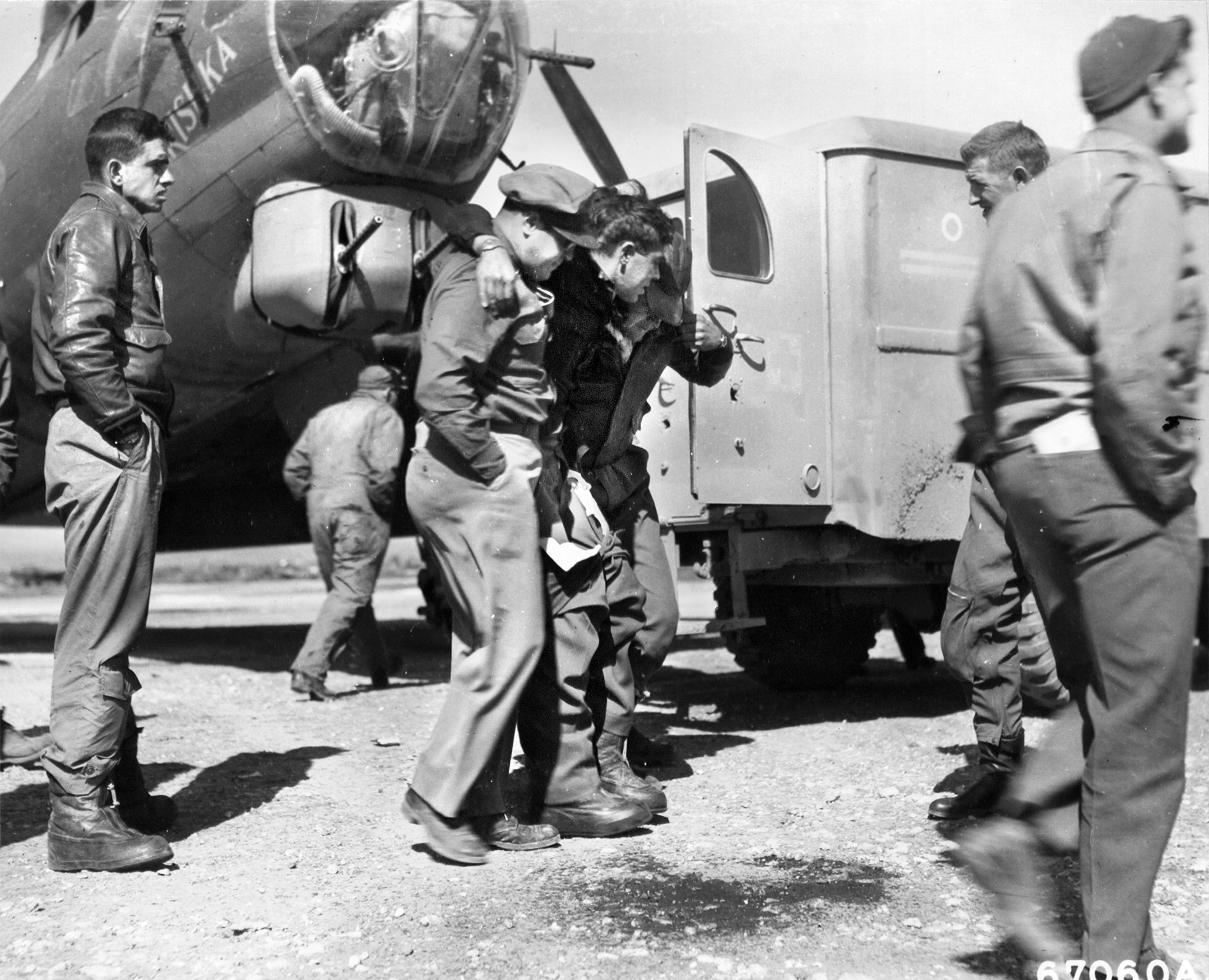 Wounded in action during the raid on the ball-bearing factory at Steyr, Austria, a crewman of a 97th Bomb Group B-24 Liberator is helped to a first aid tent upon returning from the bombing mission and the running air battle that took place concurrently. 