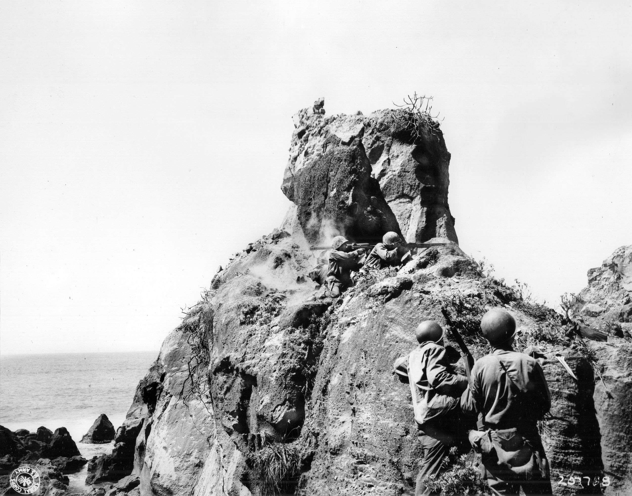 Moments after a bazooka team fired a round into the entrance, “Cave Men” place small-arms fire on a Japanese-held cave and sniper holes nearby with a Browning Automatic Rifle and Thompson submachine gun. With rugged combat such as this to subdue enemy soldiers, the U.S. Army’s 147th Infantry Regiment wrote the last chapter of the U.S. capture of Iwo Jima.