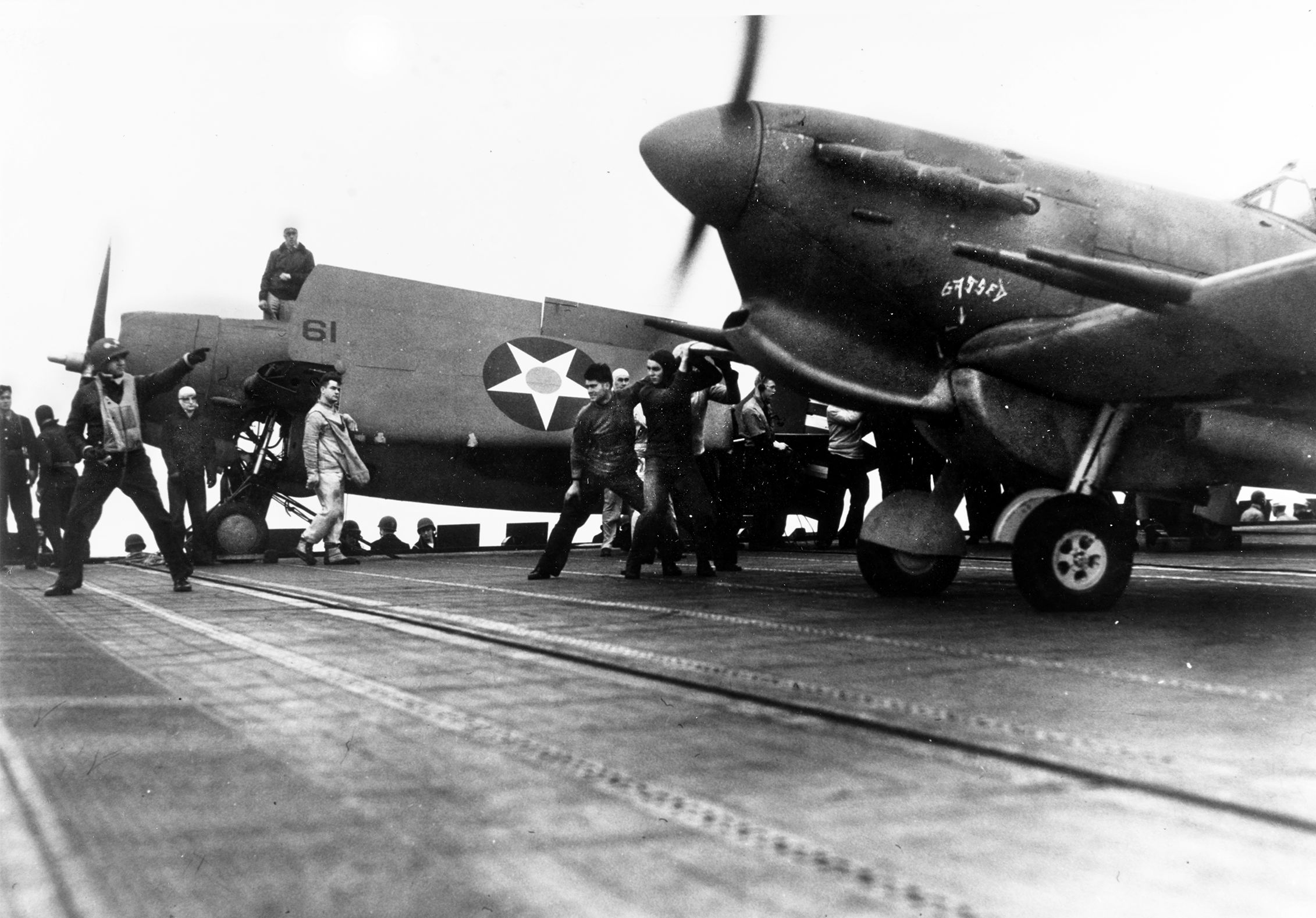 Lt. David McCampbell, launching officer aboard the aircraft carrier USS Wasp, gets the ready signal from the pilot of a British RAF Supermarine Spitfire fighter in preparation for takeoff during a ferry mission to the island of Malta. In this photo from Wasp’s second ferry mission on May 9, 1942, a Grumman F4F Wildcat fighter is seen with wings folded in the background. McCampbell went on to be the highest scoring U.S. Navy fighter ace of World War II in the Pacific with 34 aerial victories.