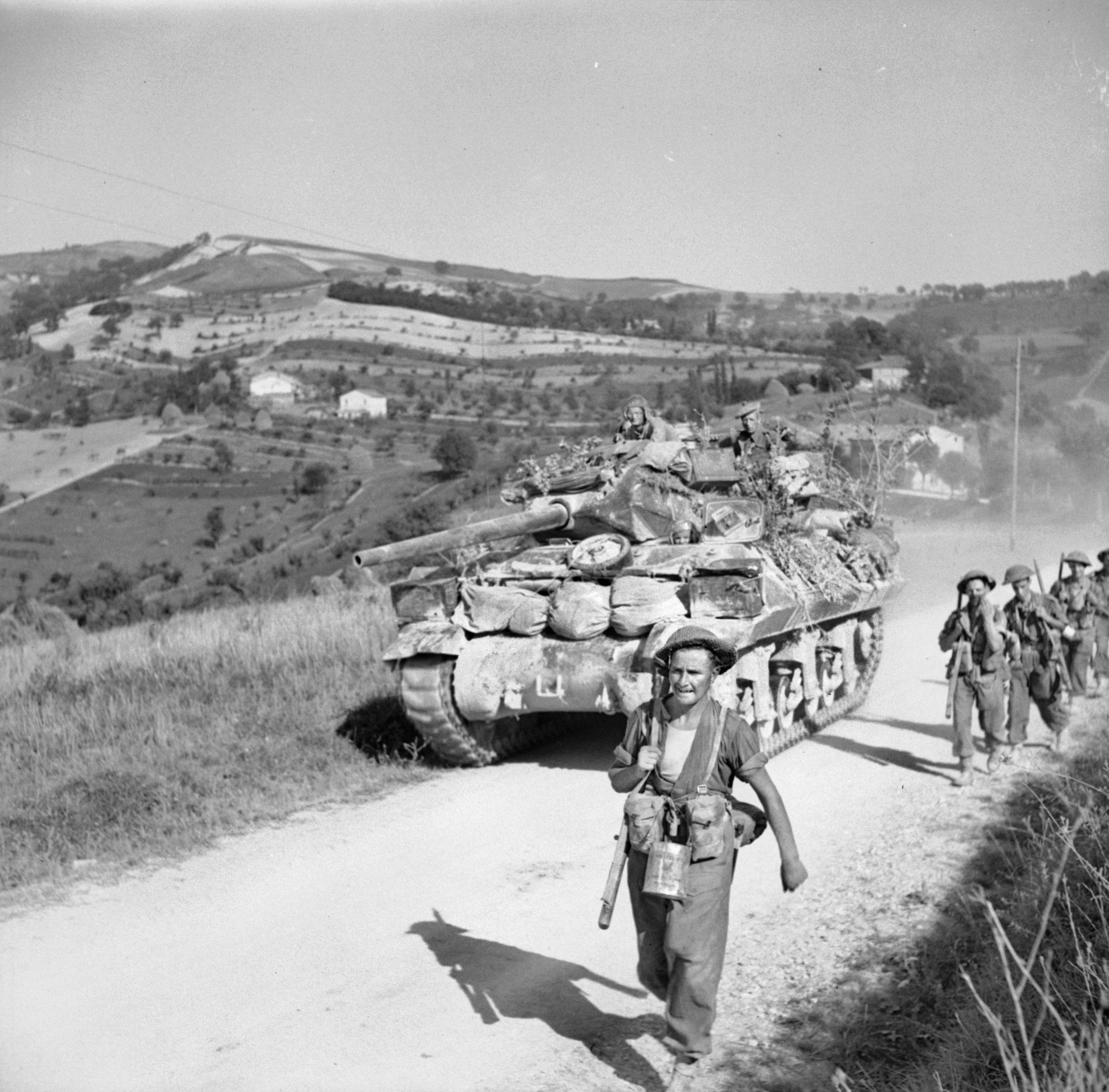 An M10 tank destroyer of the 93rd Anti-Tank Regiment passes soldiers of the 5th Sherwood Foresters in August 1944 along a dirt road during the advance toward the Apennine Mountains and the Gothic Line, the last stronghold for the German troops in Italy.