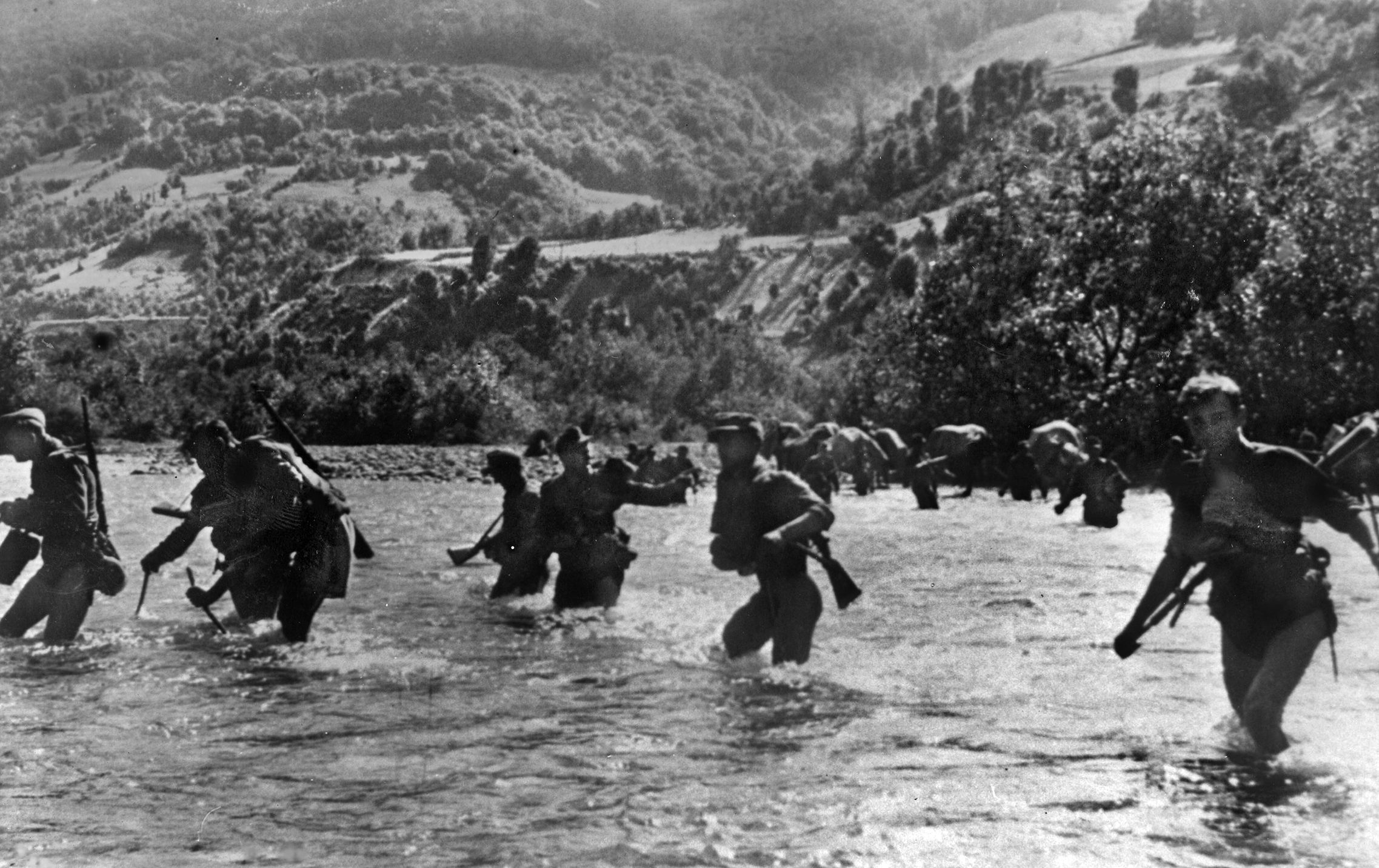 German soldiers wade across a river in Italy as they pull back to new defenses after the Gothic Line was breached. German Field Marshal Albert Kesselring coordinated a series of tactical withdrawals to new positions in the face of the Eighth Army advance. 