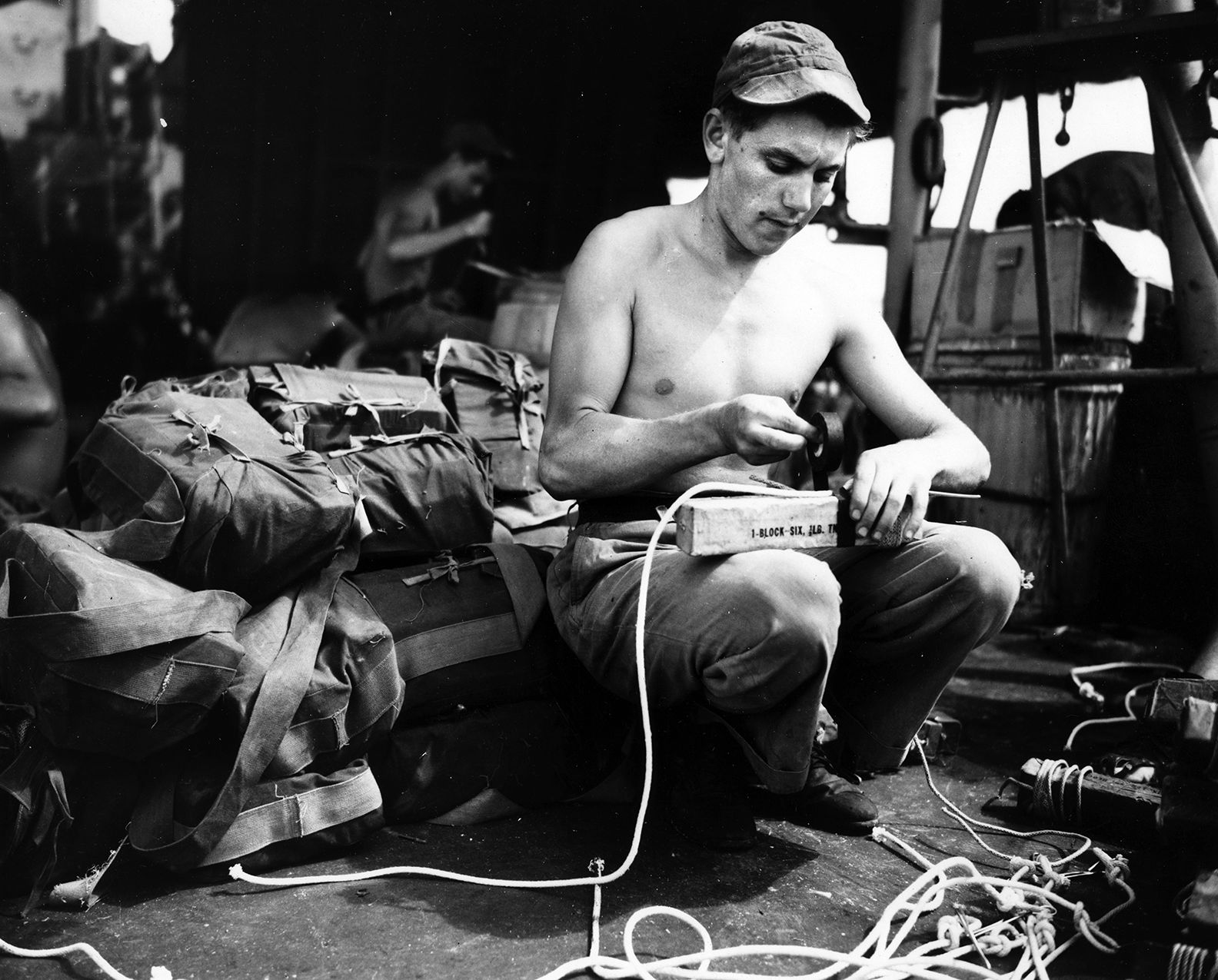 In July 1945, a U.S. Navy UDT team member rigs blocks of explosive TNT for the demolition of beach obstacles at Balikpapan, Borneo. The UDTs operated at Balikpapan in support of amphibious landings by the Australian 7th Division.