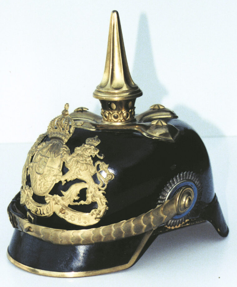 A Bavarian officer's helmet made of finer quality materials than headgear issued to enlisted men. Made of thin pressed leather, it is mounted with high quality gilded metal fittings and chinstraps.