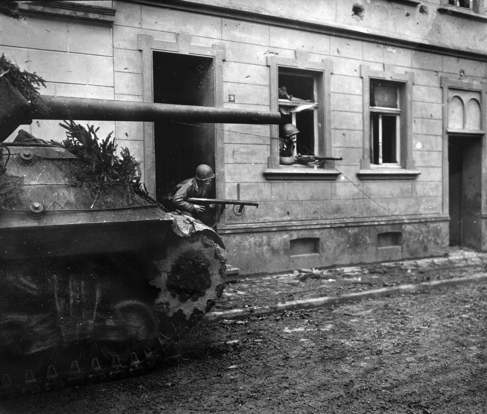 During hazardous house-to-house fighting in the town of Hürtgen, an American tank destroyer creeps forward along a cobblestone street. Throughout the forest, the Germans turned every cottage and barn into a strongpoint that had to be reduced by a formal, planned attack. 