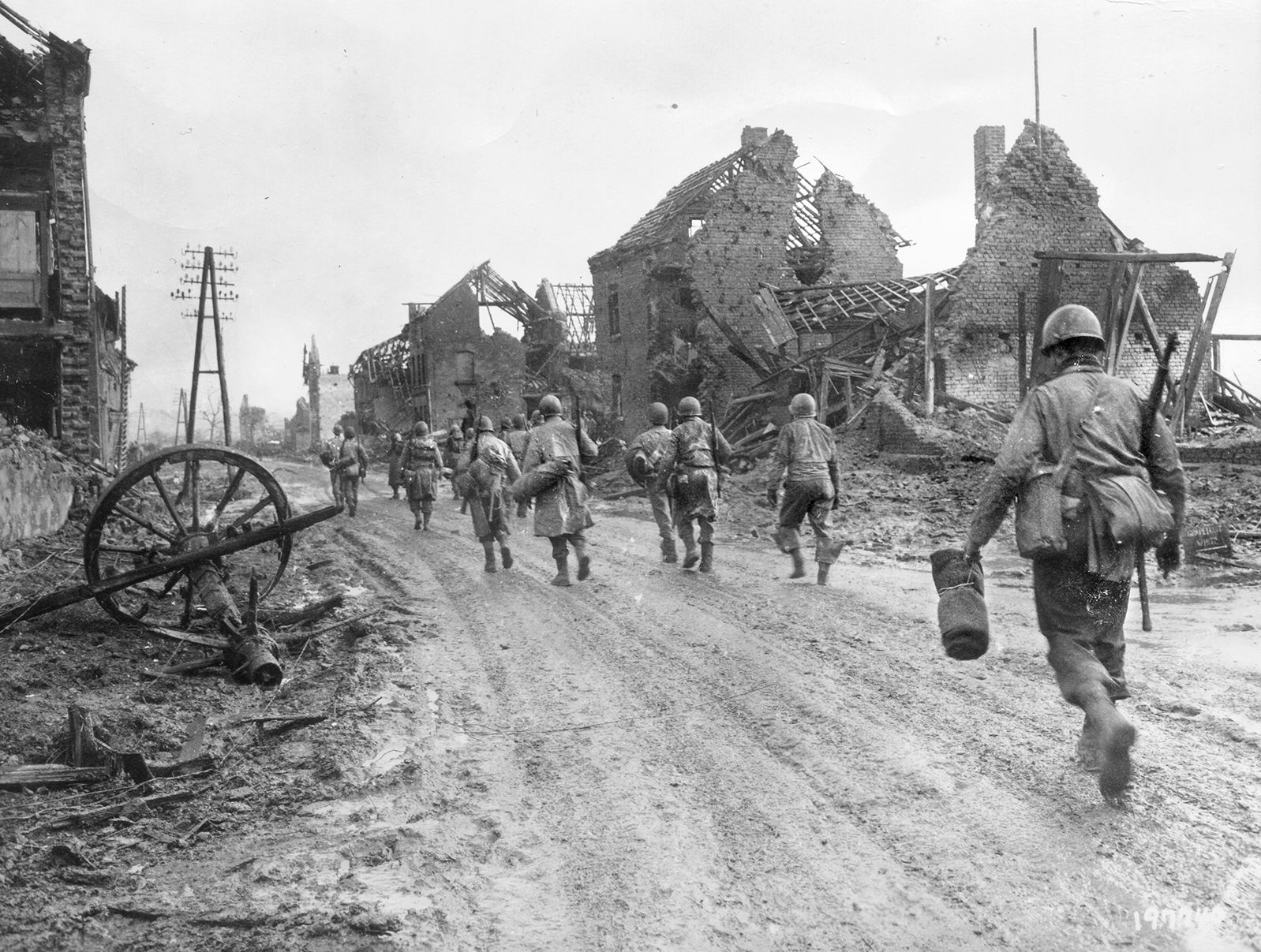 Soldiers of the Company I, 3rd Battalion, 121st Infantry Regiment trudge through the ruins of Hürtgen in December 1944. After Maj. Gen. L.T. Gerow’s V Corps 8th Infan­try cleared the town with armored support, the Germans reduced it to rubble with mortar and artillery fire.