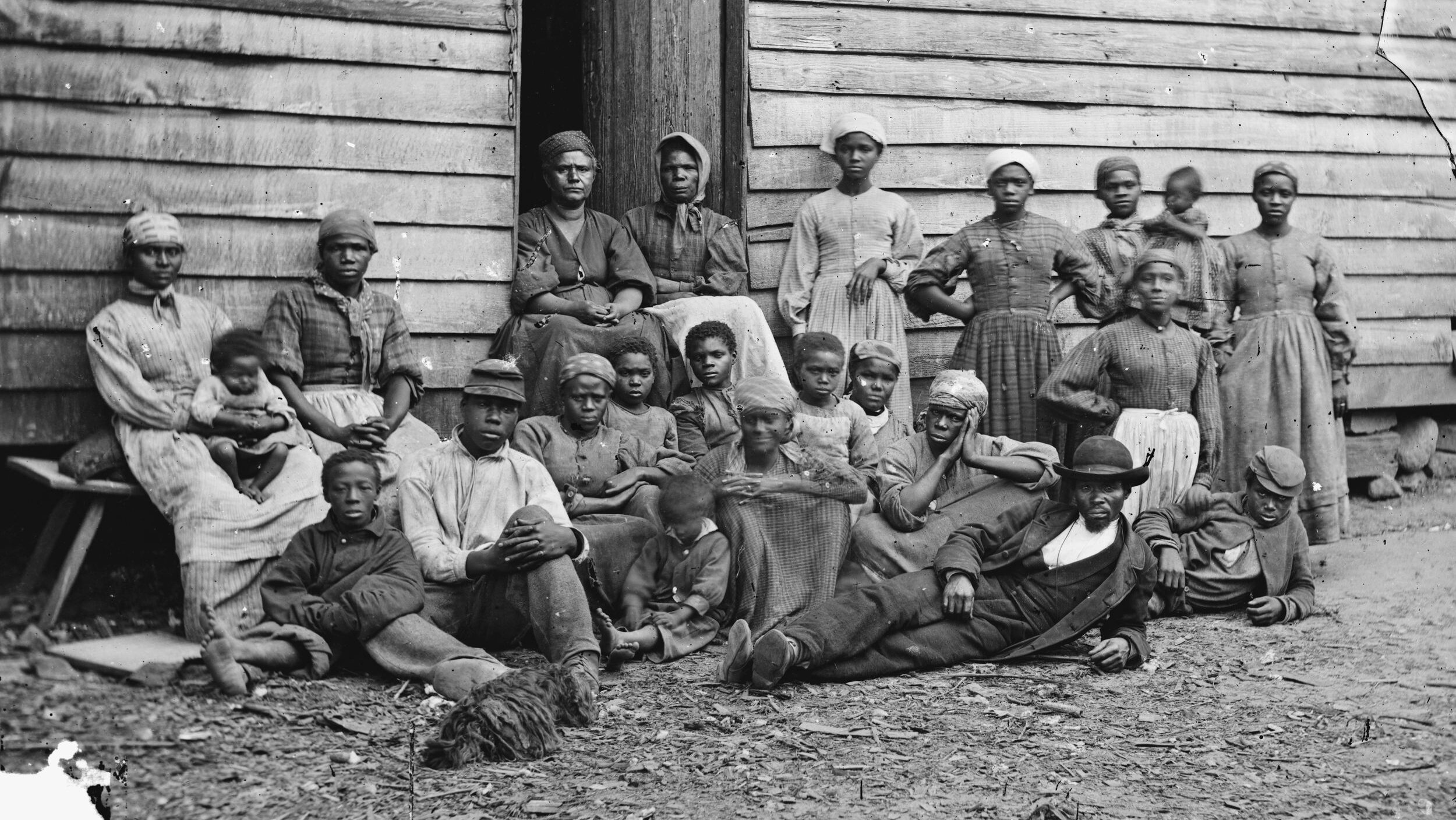 A large group of “contraband” slaves rests at a plantation near Pamunkey Run, Virginia, after escaping captivity.