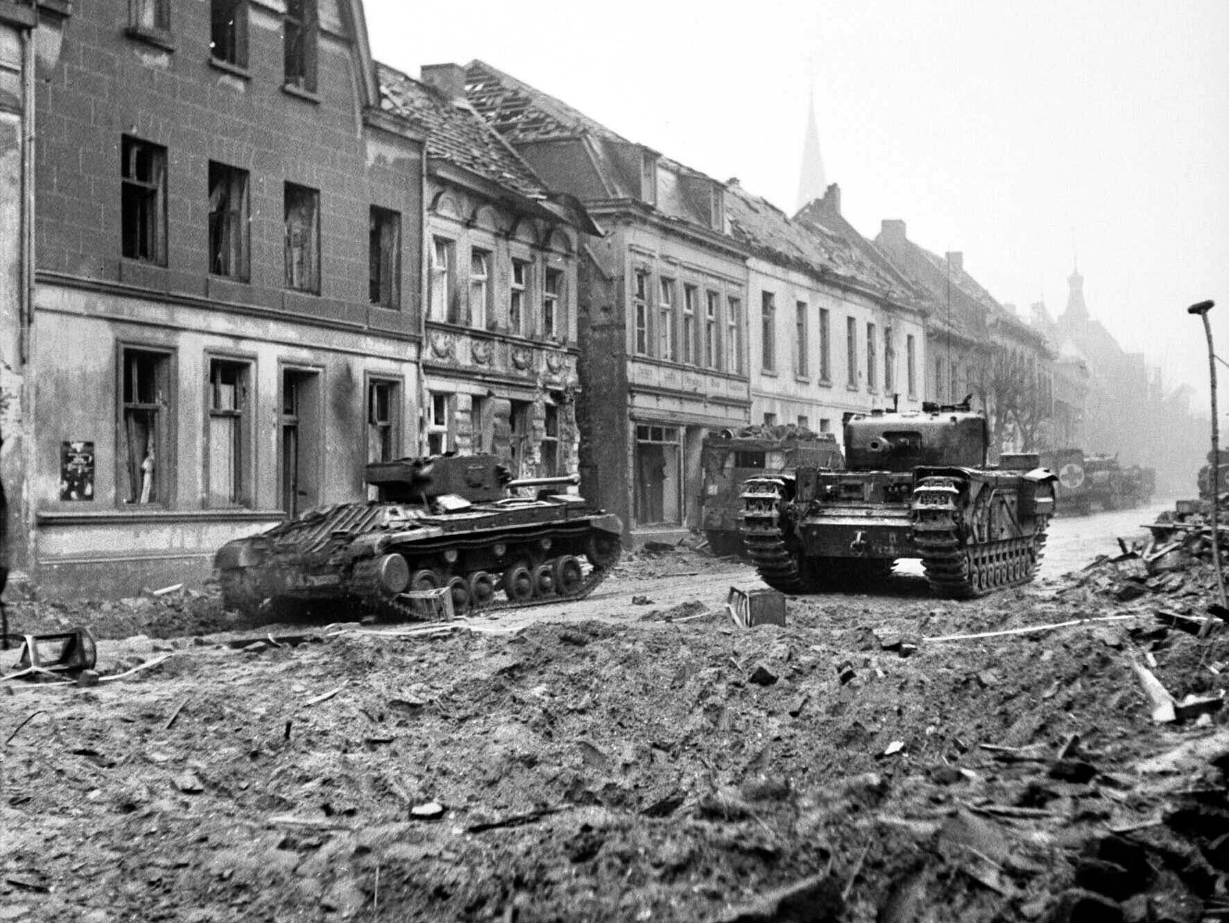 A Valentine Mk XI Royal Artillery Observation Post (OP) tank, left, and a Churchill tank move cautiously through the rubble of Goch, Germany, in late February, 1945. The British Bomber Command had sent heavy bombers to reduce the towns of Kleve and Goch to rubble on February 7.