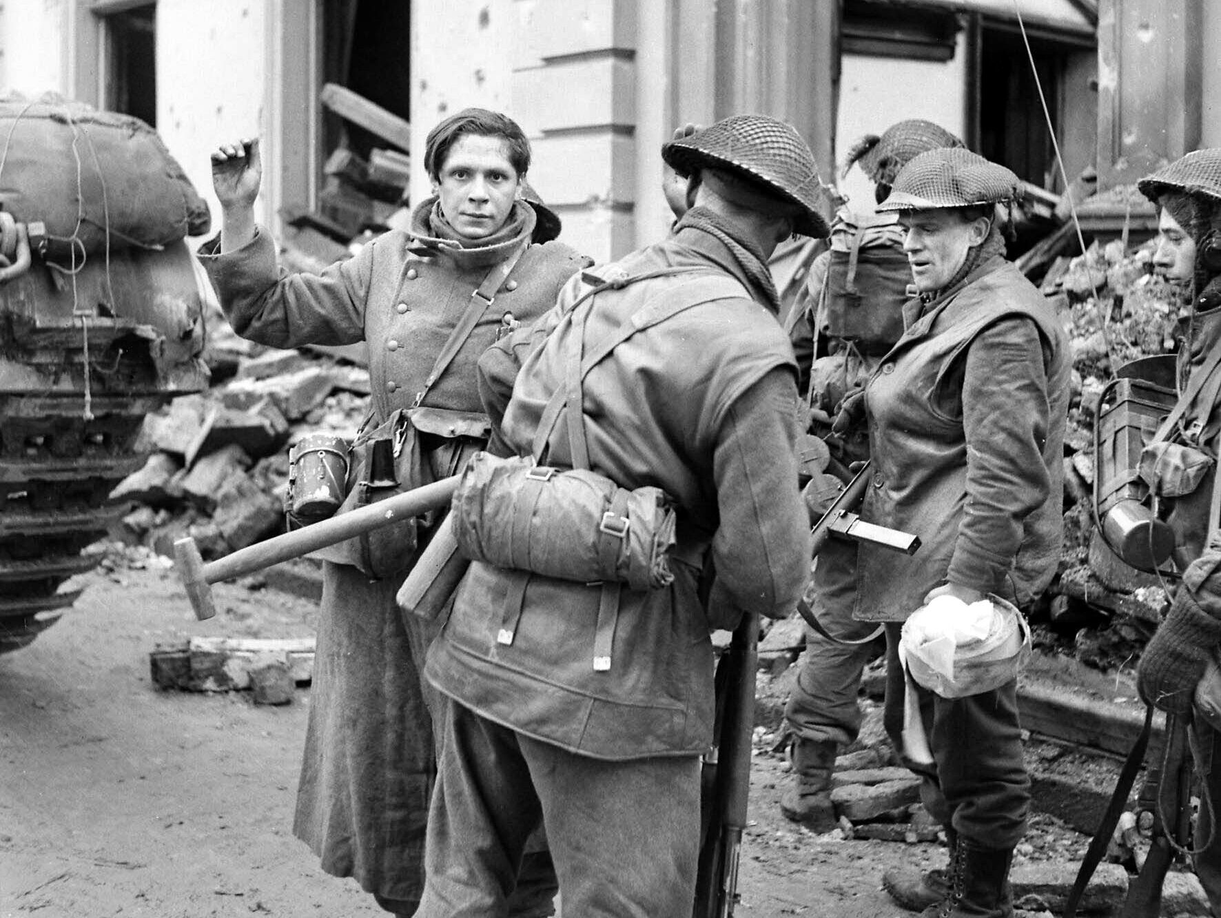 After the capture of Kleve in the lower Rhine region of northwestern Germany, soldiers from the 2nd Gordon Highlanders search a 16-year-old German prisoner on February 14, 1945.