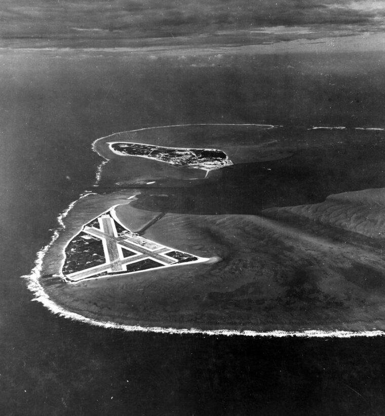 The vital airstrip on Midway’s Eastern Island, with Sand Island and its numerous facilities in the distance, is shown in this aerial view of Midway Atoll from November 1941.
