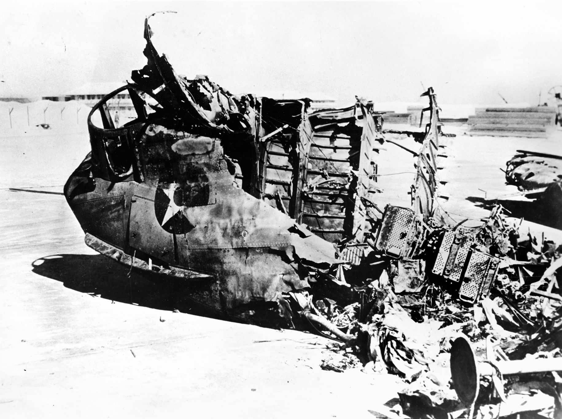 The wreckage of a Consolidated PBY Catalina flying boat lies ashore on Midway Atoll. The destructive shelling of the atoll by two Japanese destroyers occurred just hours after the attack on Pearl Harbor that plunged the United States into World War II.