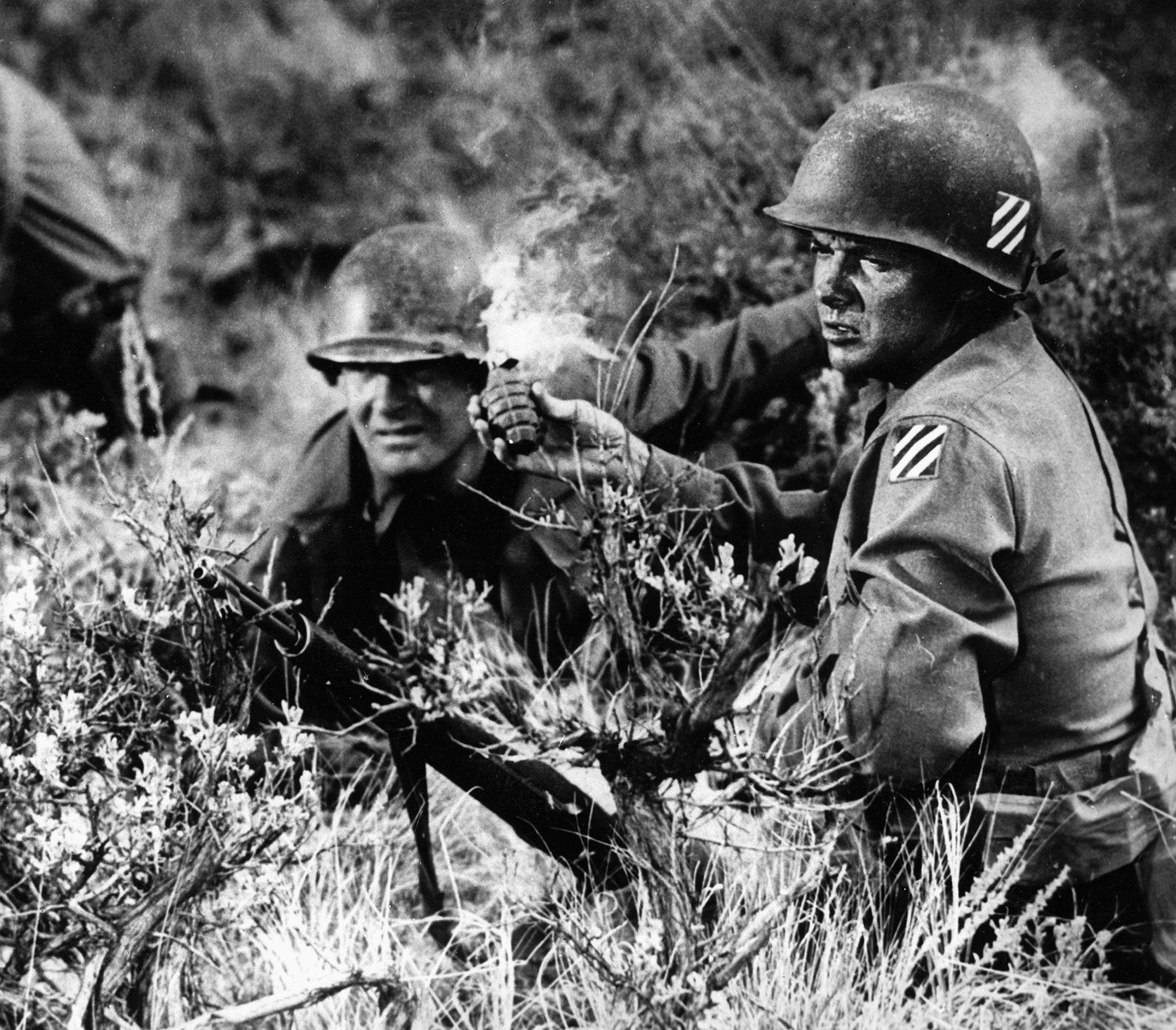 This photo from the 1955 film To Hell and Back—based on his autobiography of the same name—shows Audie Murphy, portraying himself, preparing to throw a hand grenade at a German position on “Pillbox Hill,” the sharp battle for which he received the Distinguished Service Cross for heroism. 