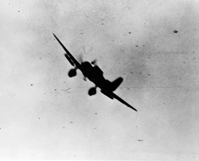 On the morning of December 7, two Japanese Zero fighters circle a downed American aircraft they had attacked near Ewa Air Station. Some observers believe the downed plane is a Douglas SBD Dauntless dive bomber from the aircraft carrier USS Enterprise. The photo was taken by a crewman from a Boeing B-17 Flying Fortress bomber approaching Hickam Field on Ford Island at Pearl Harbor during a flight from California.