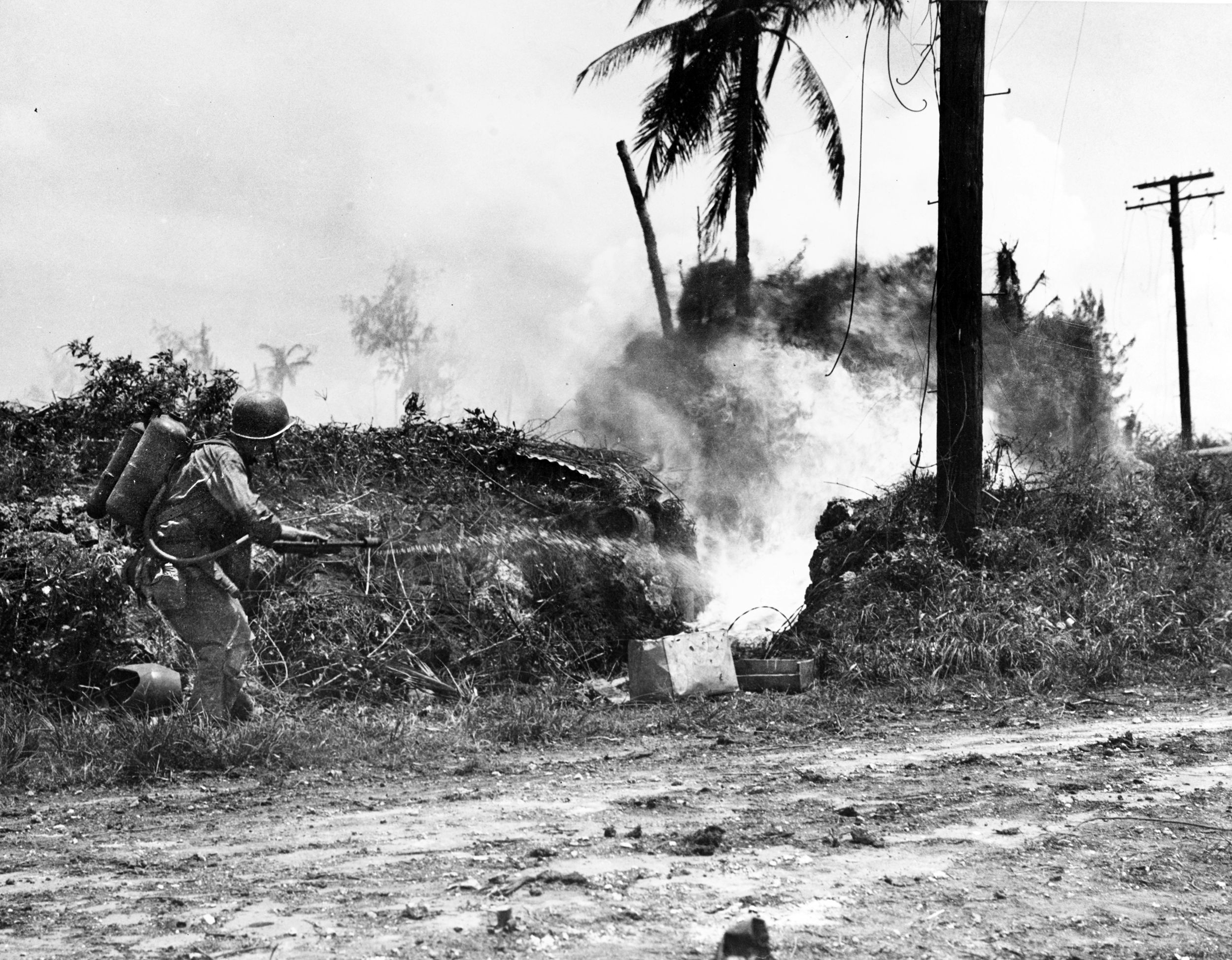 A U.S. Marine uses a flamethrower to subdue the Japanese defenders occupying a fortified bunker on the island of Guam.