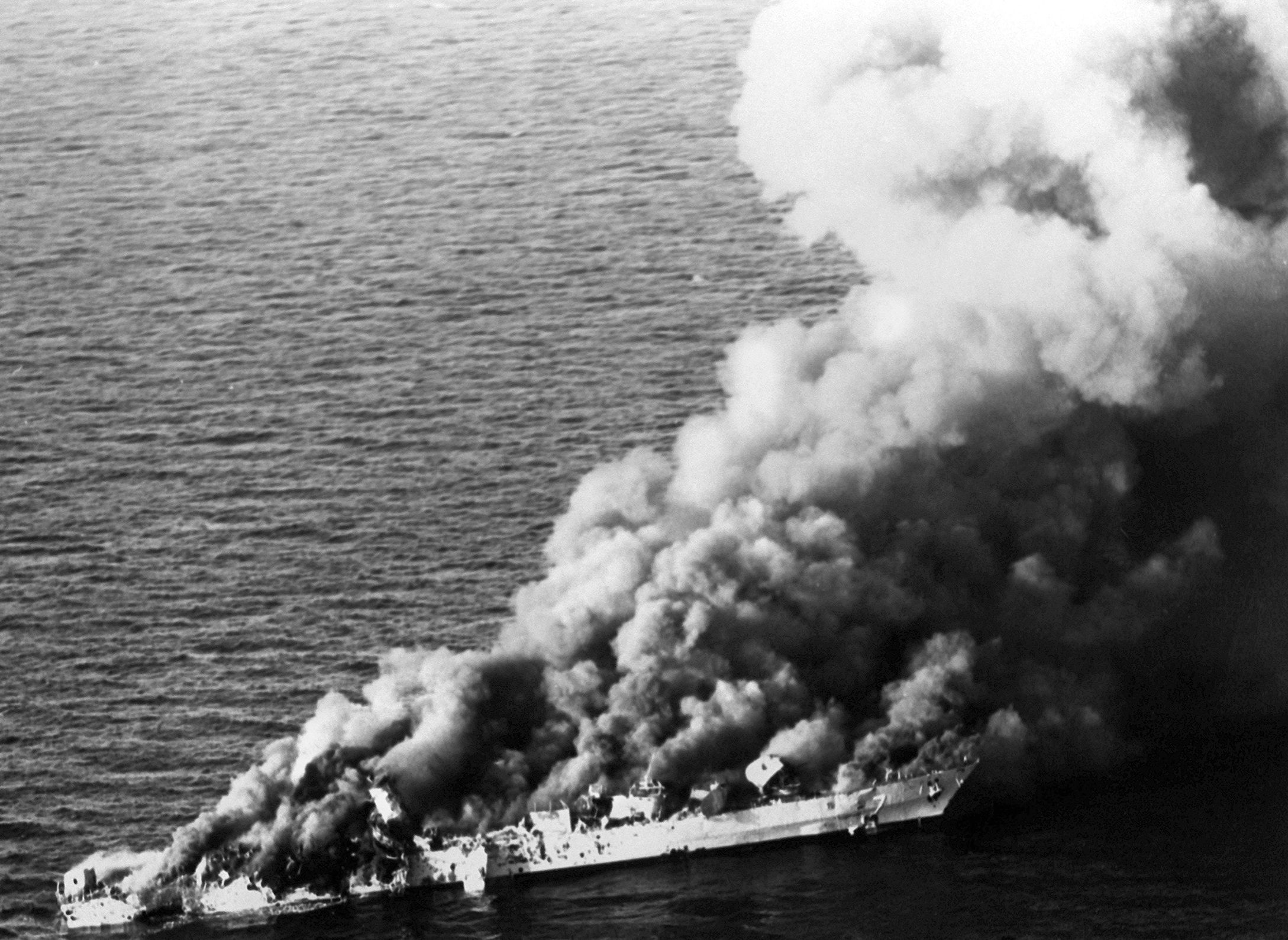The Islamic Republic of Iran Navy frigate Sahand burns in the Persian Gulf after being hit by three Harpoon anti-ship missiles, two 1,000-lb. laser-guided Skippers, two Walleye TV-guided bombs, as well as numerous Mk83 1,000-lb. bombs and cluster bombs. When the fire reached its magazine, the ship exploded and sank with the loss of 45 crewmembers. 