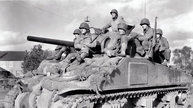 Soldiers of the U.S. 36th Infantry Division riding an M4A3 (75) “Sherman” tank of the 3rd Armored Division on October 14, 1944, near the town of Stolberg, Germany, just three miles east of Aachen.
