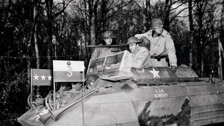 As the U.S. Third Army fights its way from the Saar River to the German border, Lt. Gen. George Patton takes ambassador to the Soviet Union Averell Harriman on a tour of the front in his personal modified M20 armored scout car. From left are British Lt. Col. James Gault (Eisenhower’s aide-de-camp), Harriman, and Patton.