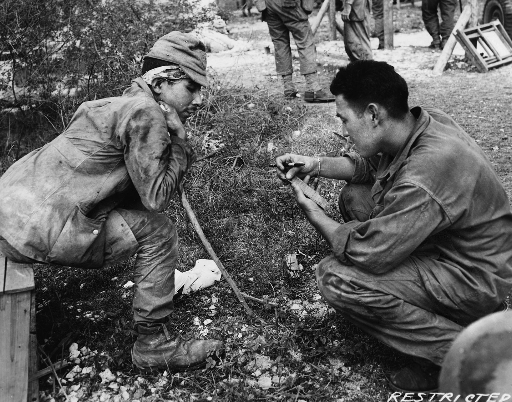 One of seven Nisei translators attached to the 27th Infantry Division interrogates a Japanese POW on Saipan. The head of the language unit, 2nd Lt. Benjamin H. Hazard, was unsuccessful in convincing his superiors that the coming attack, a gyokusai, would be unlike any they’d seen before. This “is not just yelling and screaming and coming in,” Hazard explained. The singing that could be heard meant “they know they’re going to die.” 
