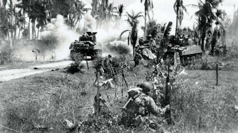 Infantry from the 40th Division follows Sherman tanks advancing on Japanese positions on Panay Island, Philippines in March 1945. This photograph is one of four from the camera of Lt. Robert Fields who was killed by incoming Japanese fire shortly after this photo was taken.