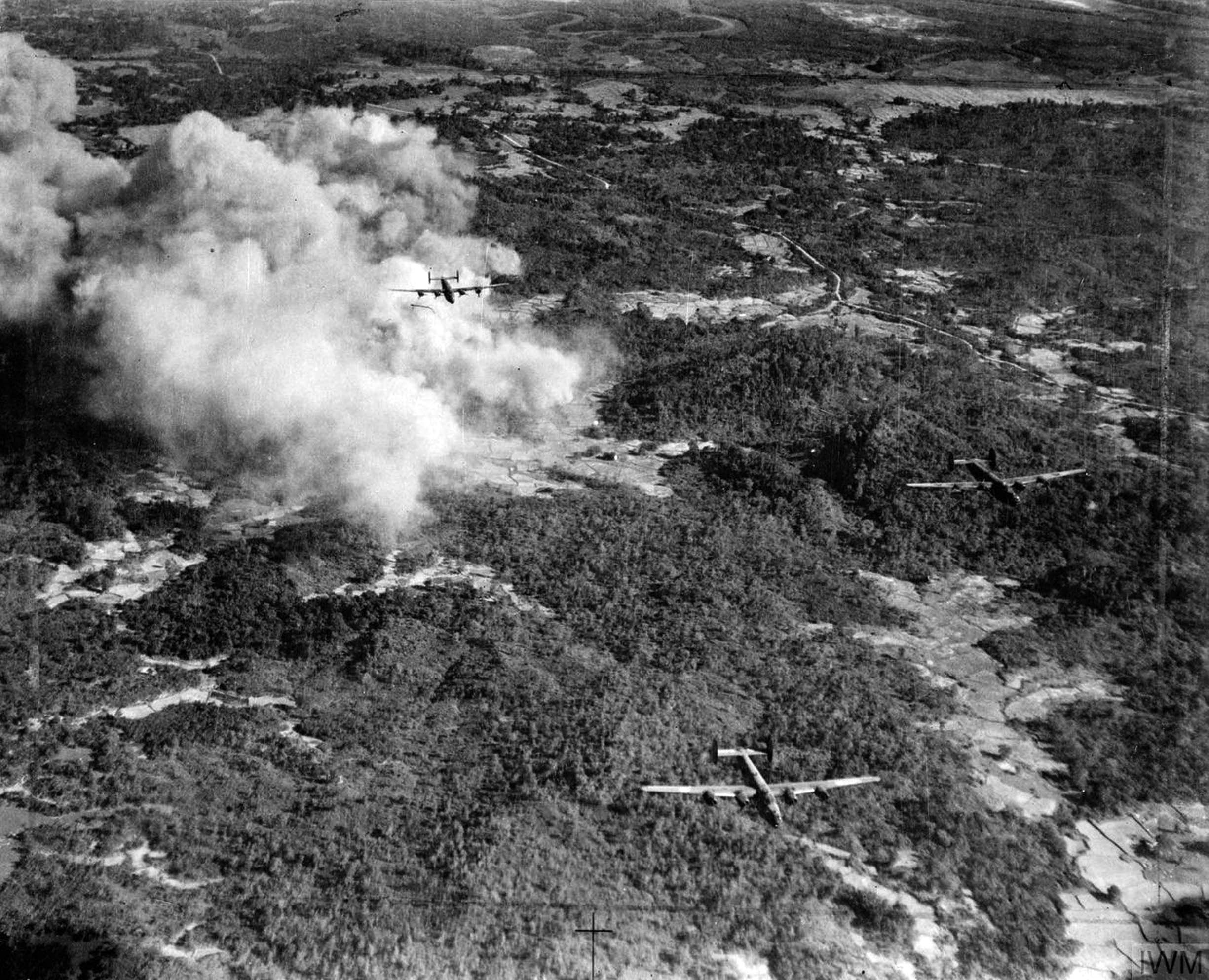 Three Consolidated Liberator B Mark VIs, a special version of the B-24 flown by the RAF, have just dropped their payloads over Japanese positions marked with smoke on Ramree Island, Burma, ahead of the beach landing by the 26th Indian Division on January 21, 1945. The Royal Navy battleship HMS Queen Elizabeth and light cruiser HMS Phoebe also fired thousands of artillery shells at the island.