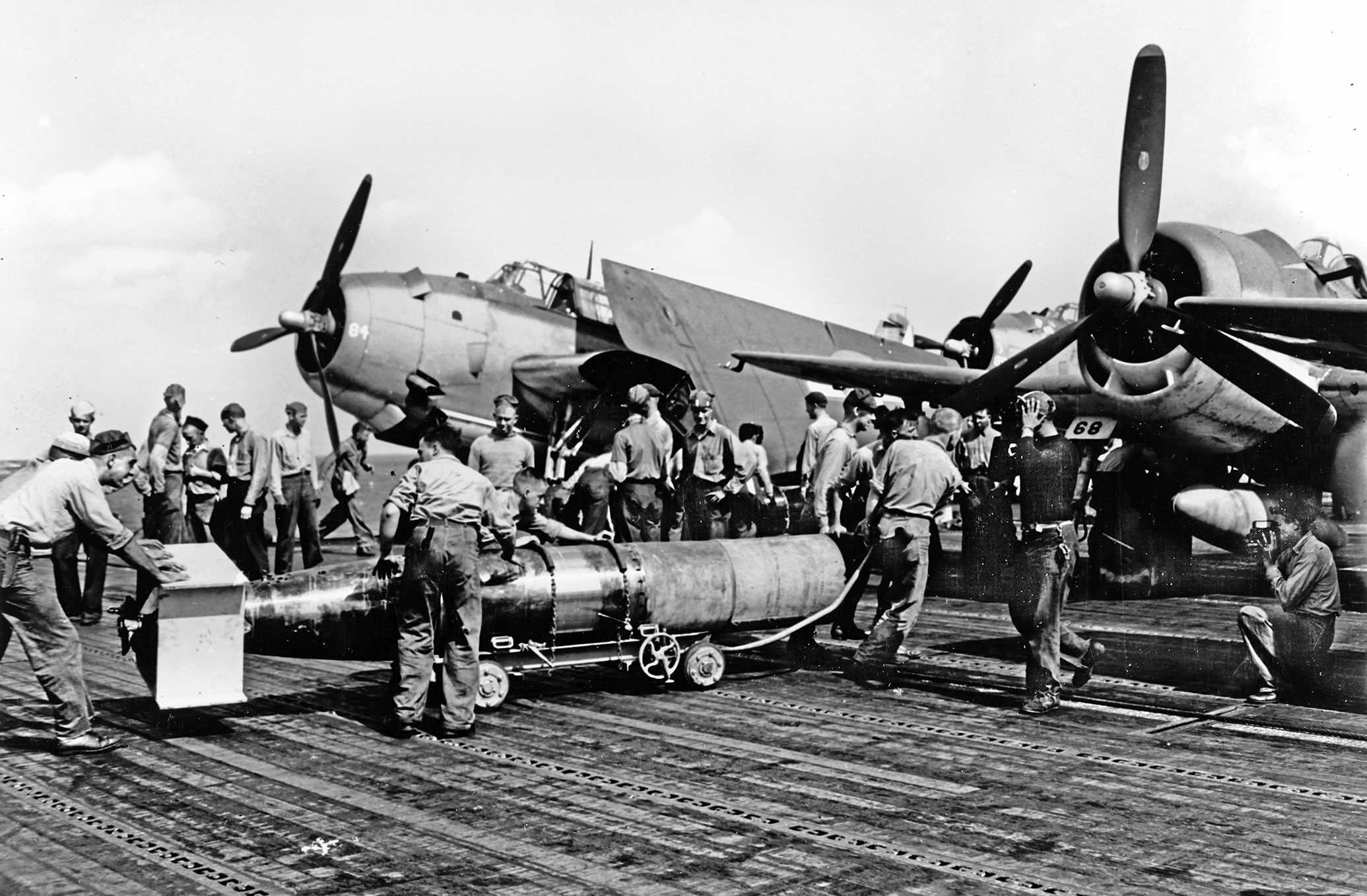 A crew loads an Mk XIII torpedo being loaded on a Grumman TBF Avenger aboard the USS Wasp in 1944. At 13 feet long and 22.4 inches in diameter, a combat-ready Mk XIII weighed about 2,200 lbs, including 600 lbs of Torpex high explosive. To mount the Mk XIII on the Skyraiders in 1951, the dive brake in the middle of the fuselage had to be disabled. The plywood boxes protecting the torpedo’s tailfins, propeller, and nose were designed to break off on impact.