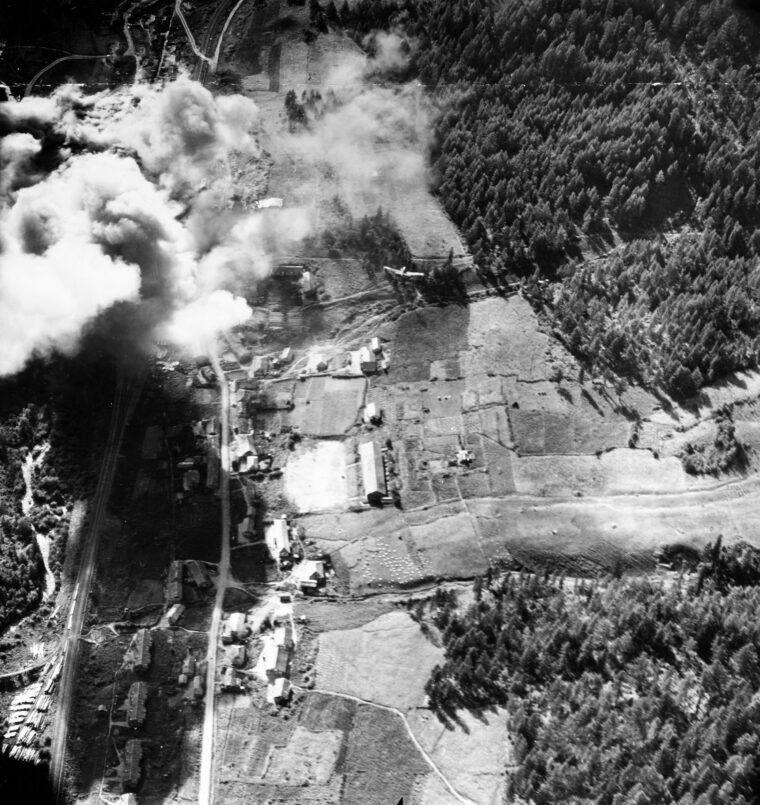 A diving Navy Douglas AD-4 Skyraider from Attack Squadron 195 “Dambusters” can be seen (in circle) just above the center of this photo of an attack on a North Korean lumber mill.