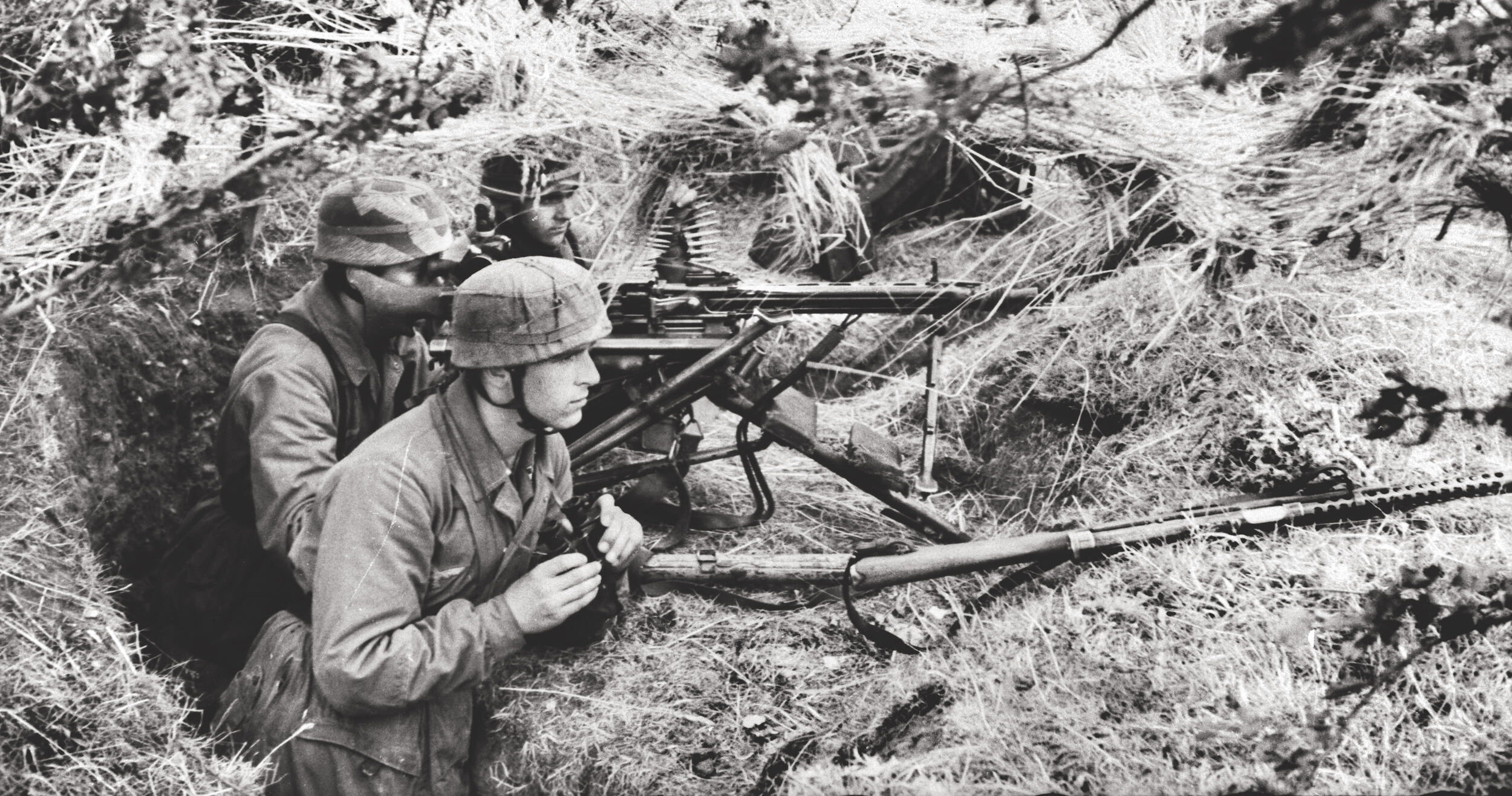 German Fallschirmjägers (Paratroopers) in an entrenched machine-gun position await the advancing Allied forces in Normandy’s le Bocage in the summer of 1944.