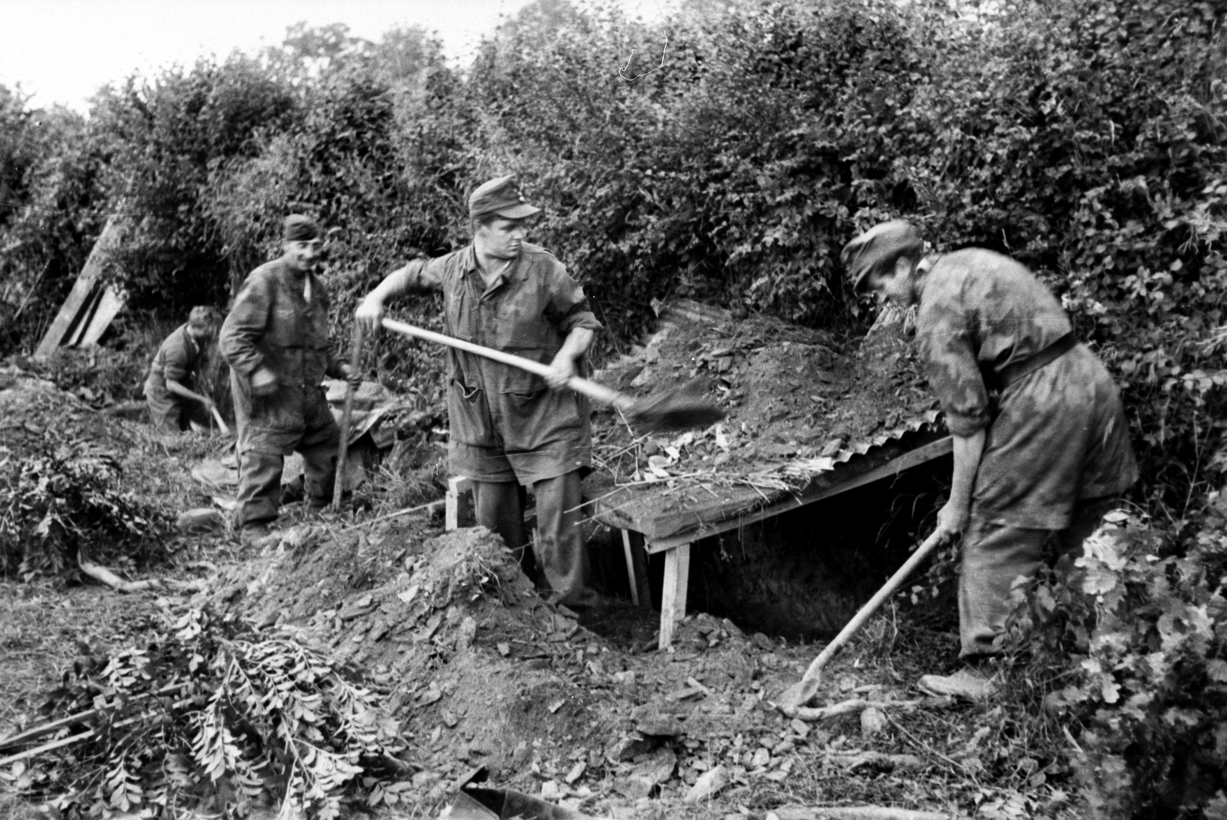 Fallschirmjägers (paratroops) fortify defensive positions in the hedgerows of Normandy’s bocage region in 1944. To withstand artillery rounds, they were ordered to shovel dirt over three layers of logs.