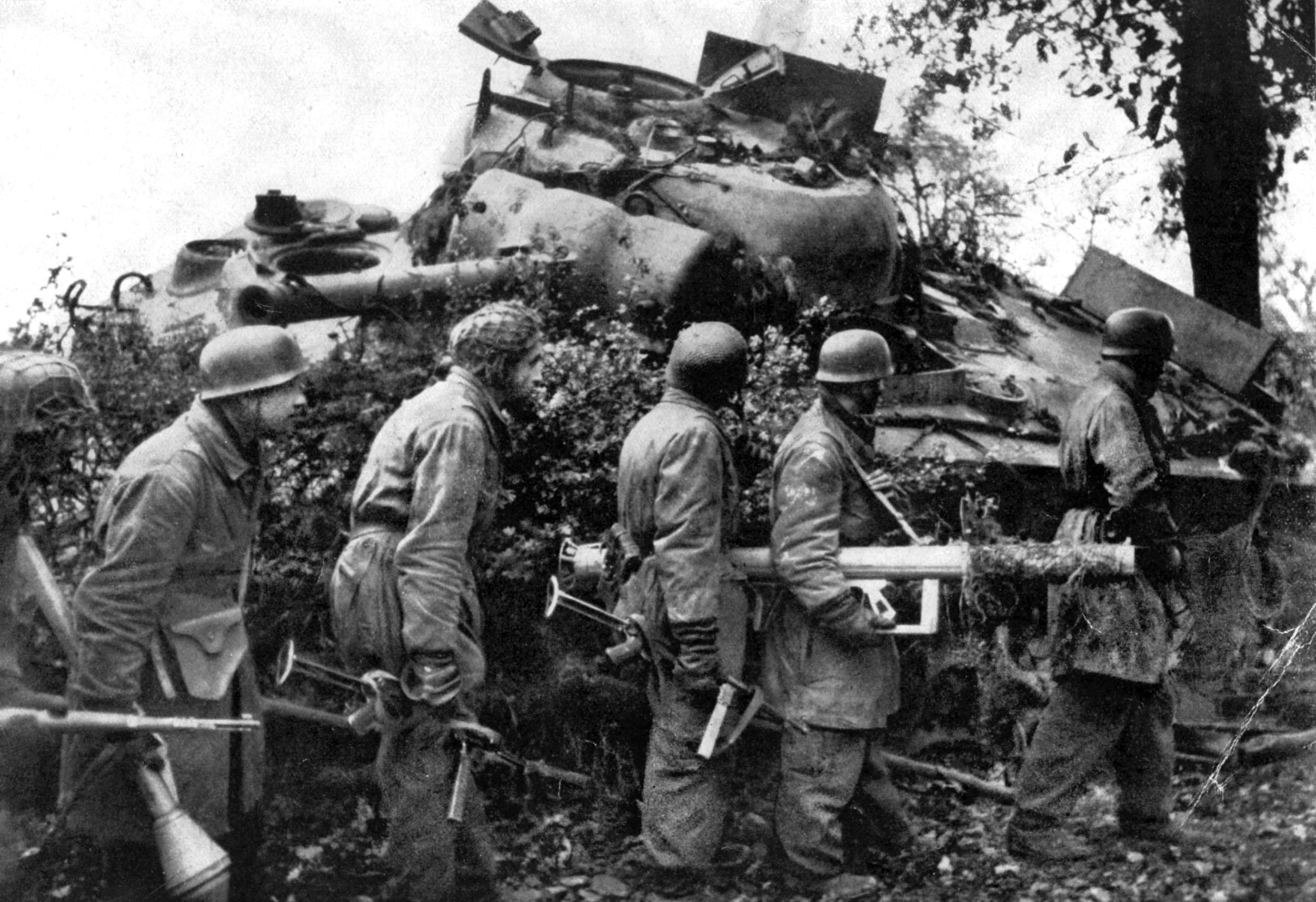 Fallschirmjägers, some with antitank weapons, inspect a knocked out U.S. Sherman tank in Normandy. In his time under fire in the hedgerow country, Rudolf Jackl fired several Panzerfausts at attacking Shermans but missed.