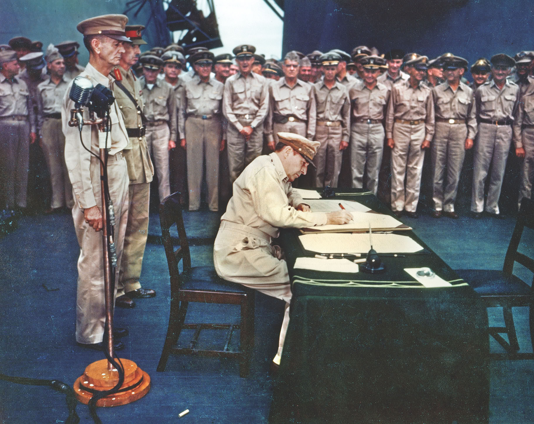 General Douglas MacArthur, Supreme Allied Commander, formalizes the end of the greatest conflict in human history. At a desk aboard the deck of the USS Missouri in Tokyo Bay, MacArthur signs the Japanese Instrument of Surrender, ushering in a new era for the Pacific and the world.
