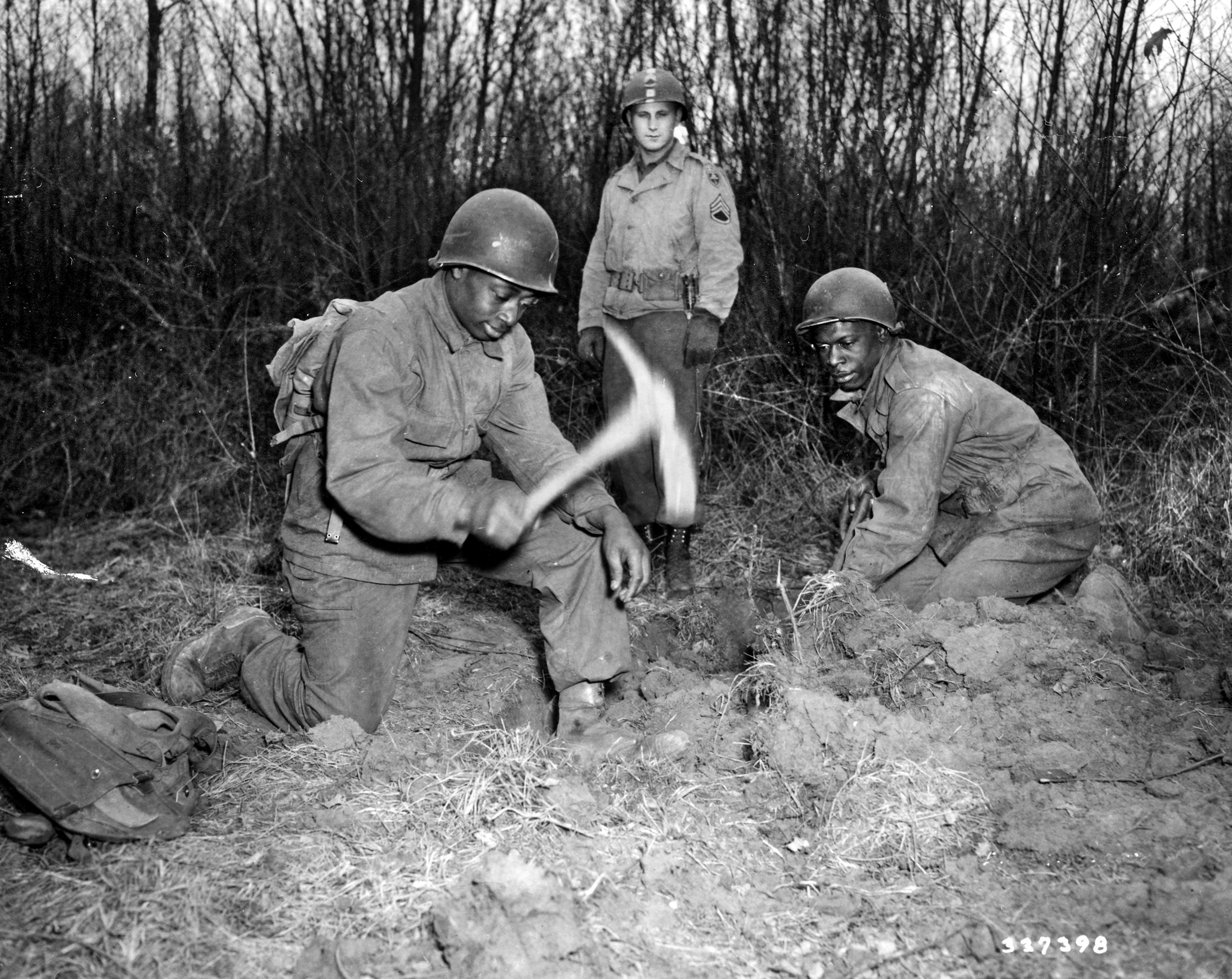 At the 47th Reinforcement Depot in February 1945, two volunteer privates who will soon be used at the front in combat units demonstrate the proper method of digging a foxhole for their veteran instructor.